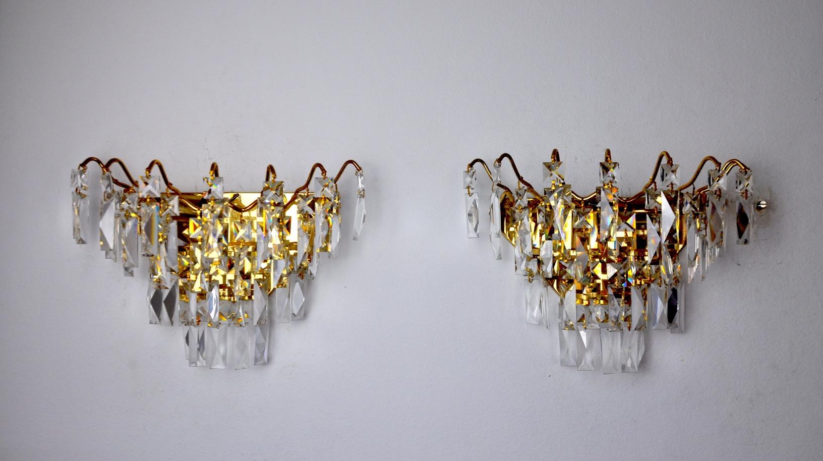 Very nice pair of hollywood regency sconces dating from the 80s. The sconces are made of cut rocca crystals and a gilded metal structure. Unique design object that will illuminate your interior wonderfully. Electricity checked, perfect state of