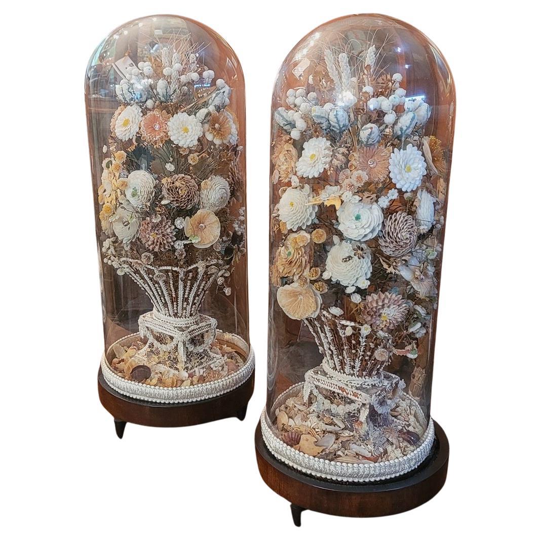Paire de bouquets floraux de style Régence en coquillage sous dômes en verre