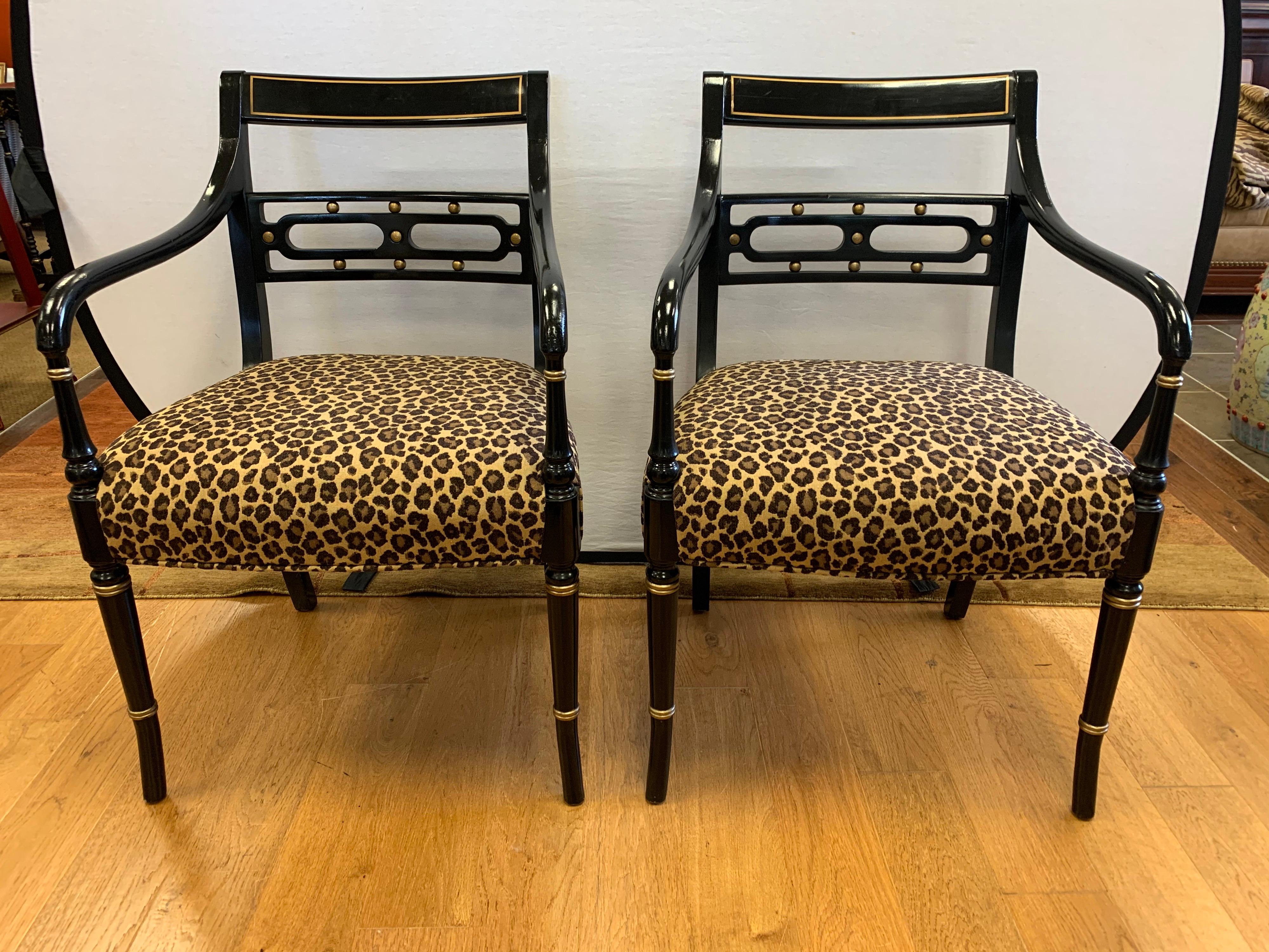 Elegant pair of Regency style dining chairs, ebonized with gold gilt highlights and newly upholstered in leopard print fabric. All dimensions are below. Upholstery is brand new and done in an elegant leopard print.