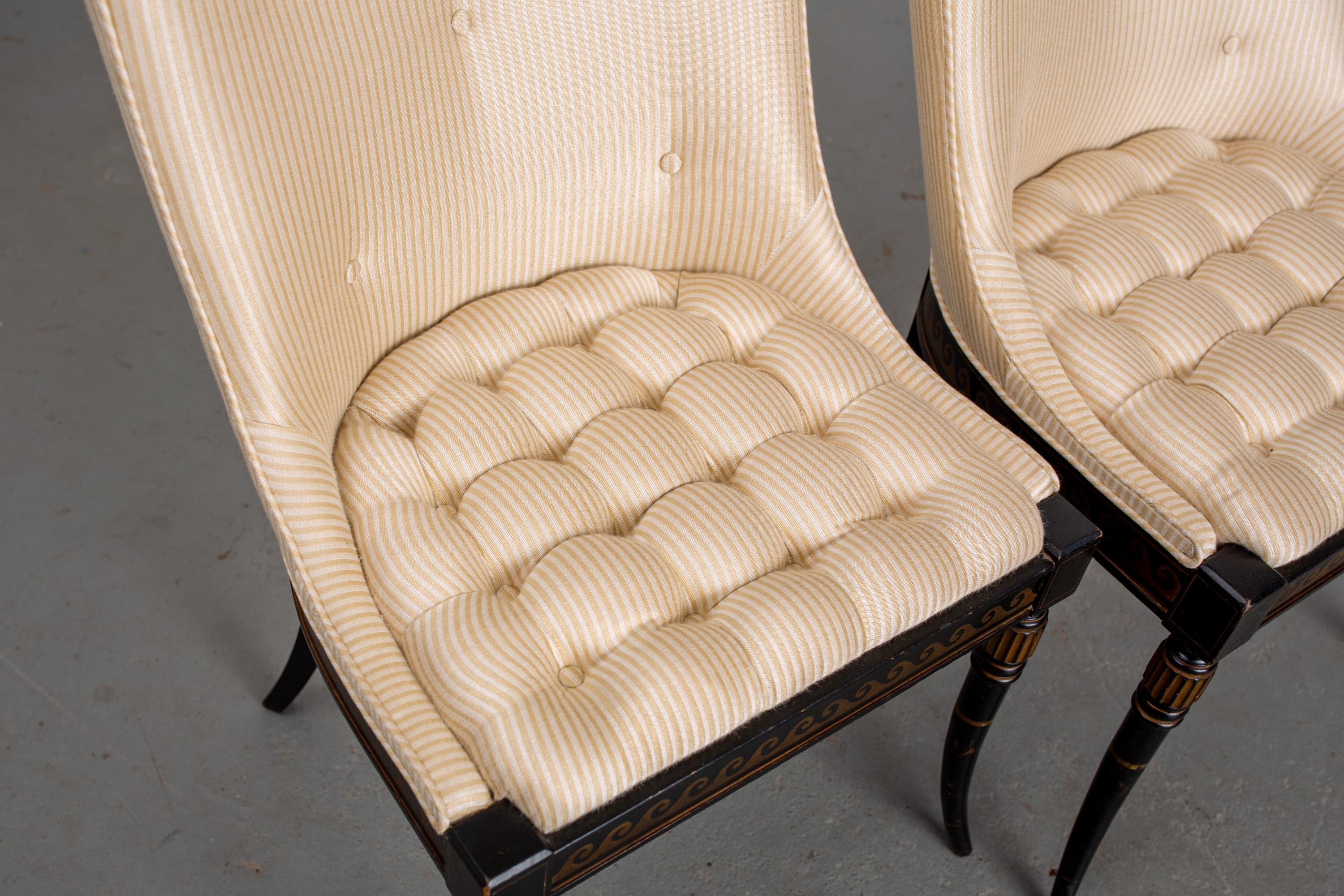 Pair of Regency style, newly upholstered, button-tufted side chairs with black painted frame and carved wood legs with parcel-gilt.