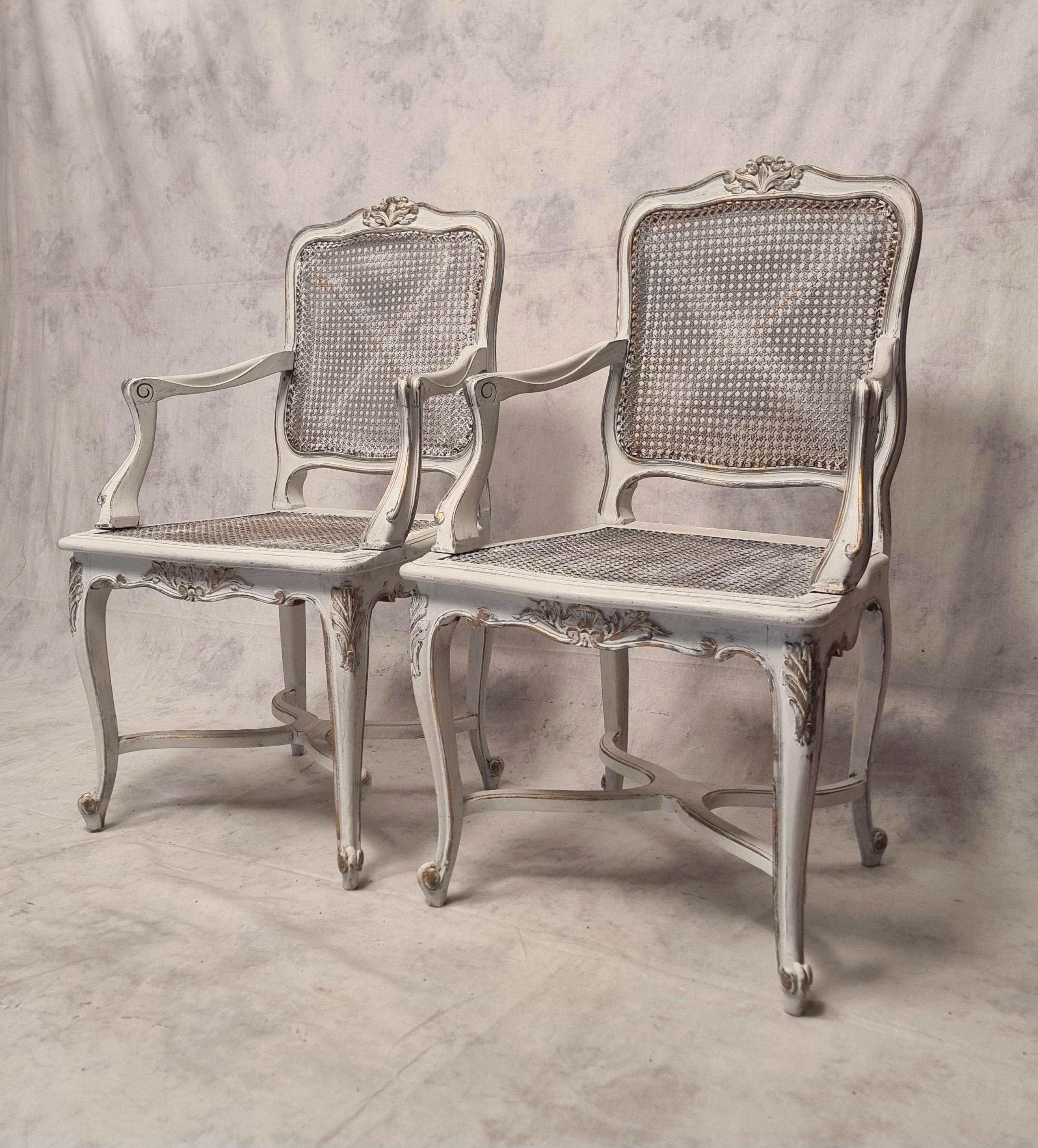 Pair of Regency style caned armchairs from the end of the 19th century. Iconic model of the Regency style, these armchairs have curved cross-shaped legs. It's armchairs are nicely animated and full of dynamism. Both the seat and the backrest are