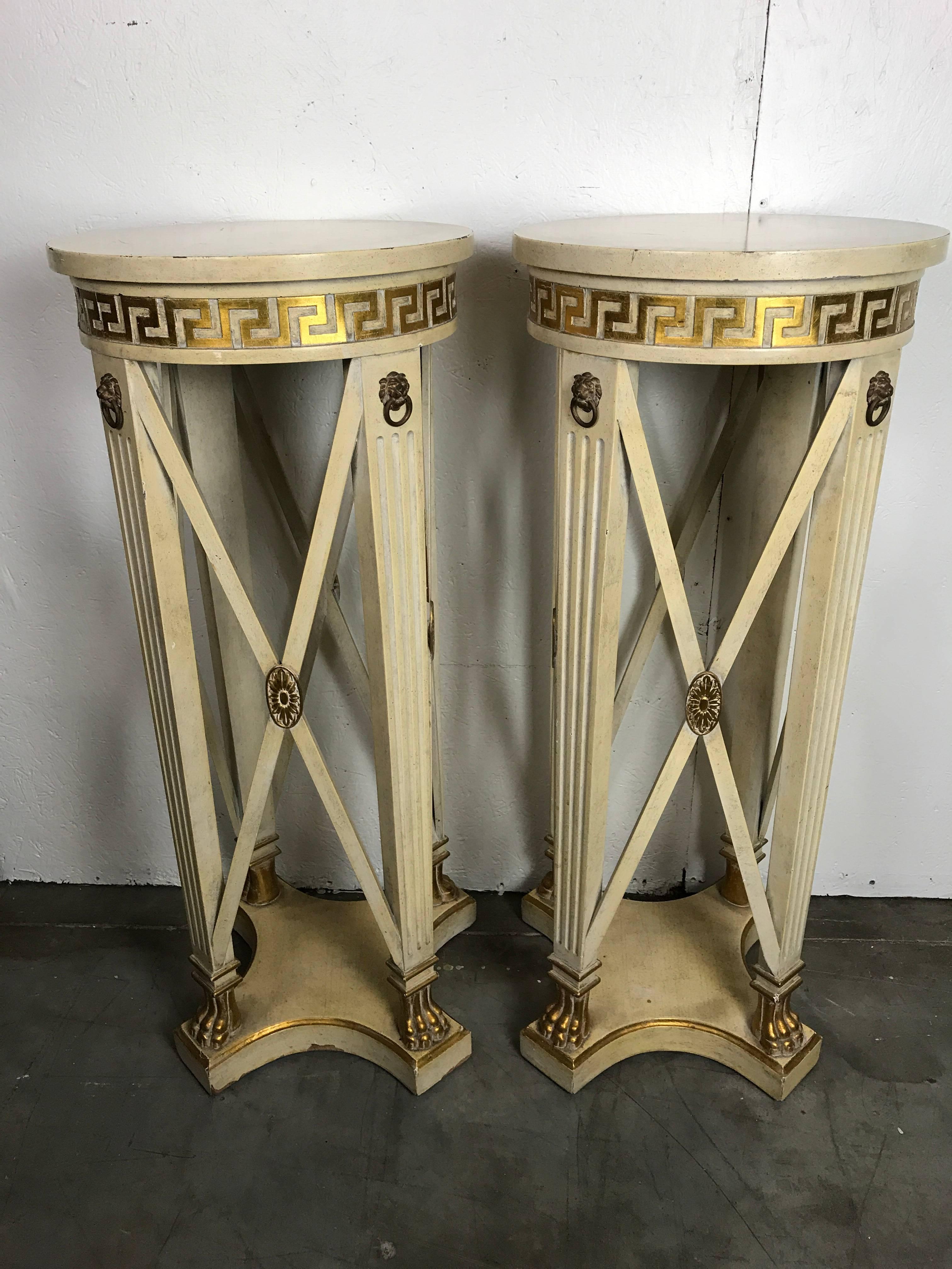 Pair of Regency style cream painted Grosfeld house pedestals, with gilt decoration and brass lion head mounts, the diameter of the top is 15
