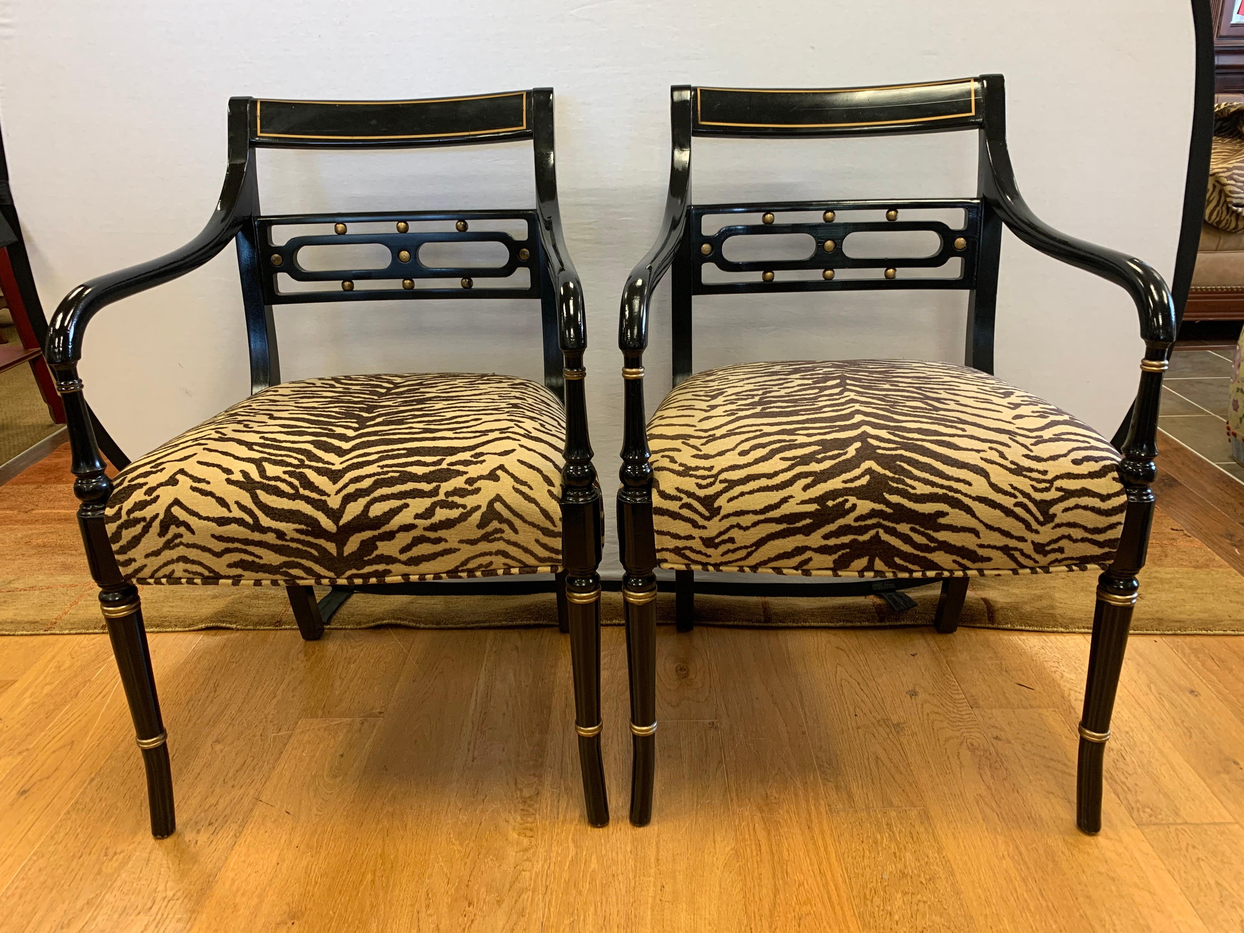 Elegant pair of Regency style dining chairs, ebonized with gold gilt highlights and newly upholstered in zebra print fabric. All dimensions are below. The upholstery is brand new and done in an elegant zebra print.