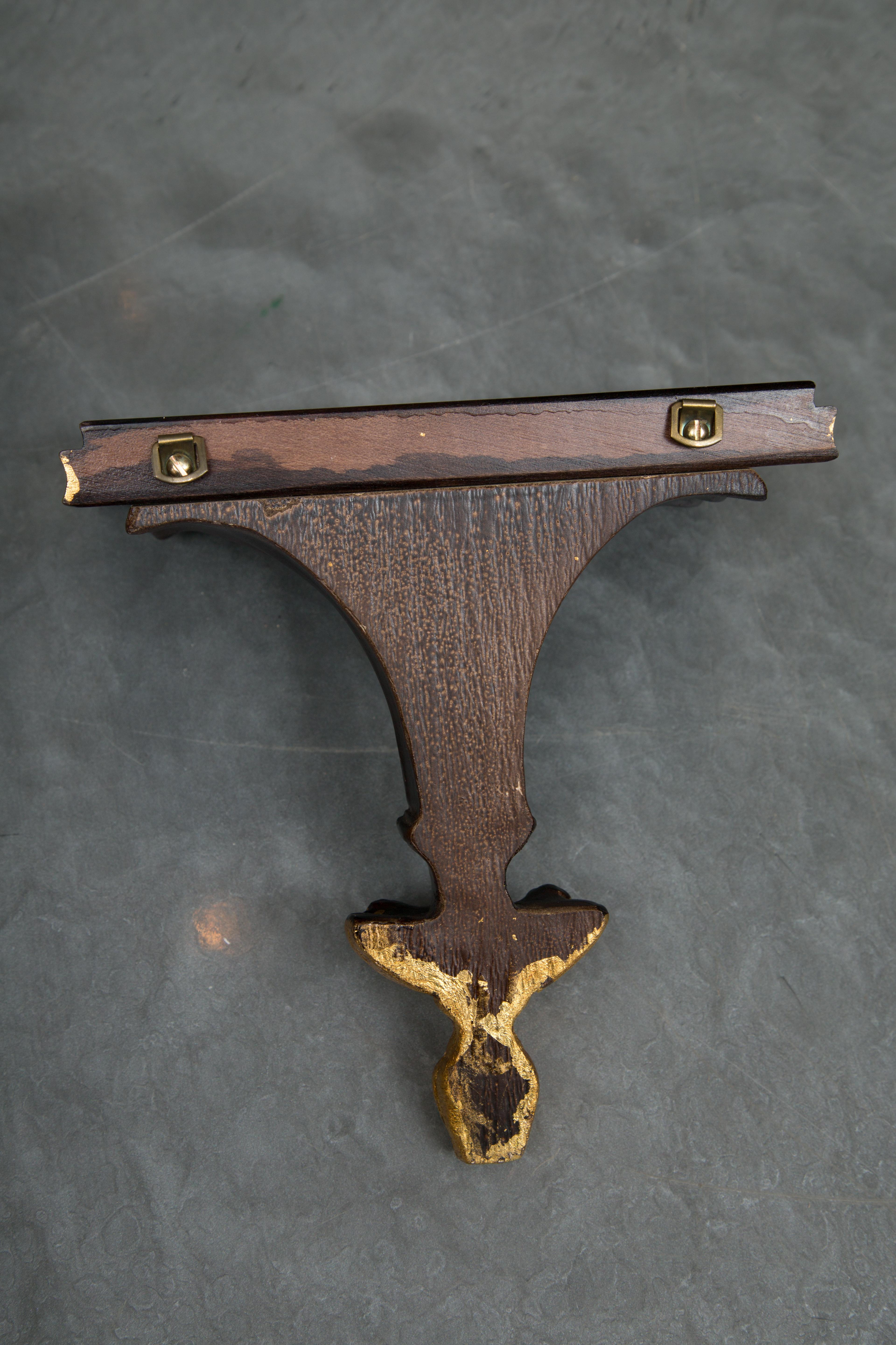 This is a decorative pair of ebonized and parcel brackets, 20th century.