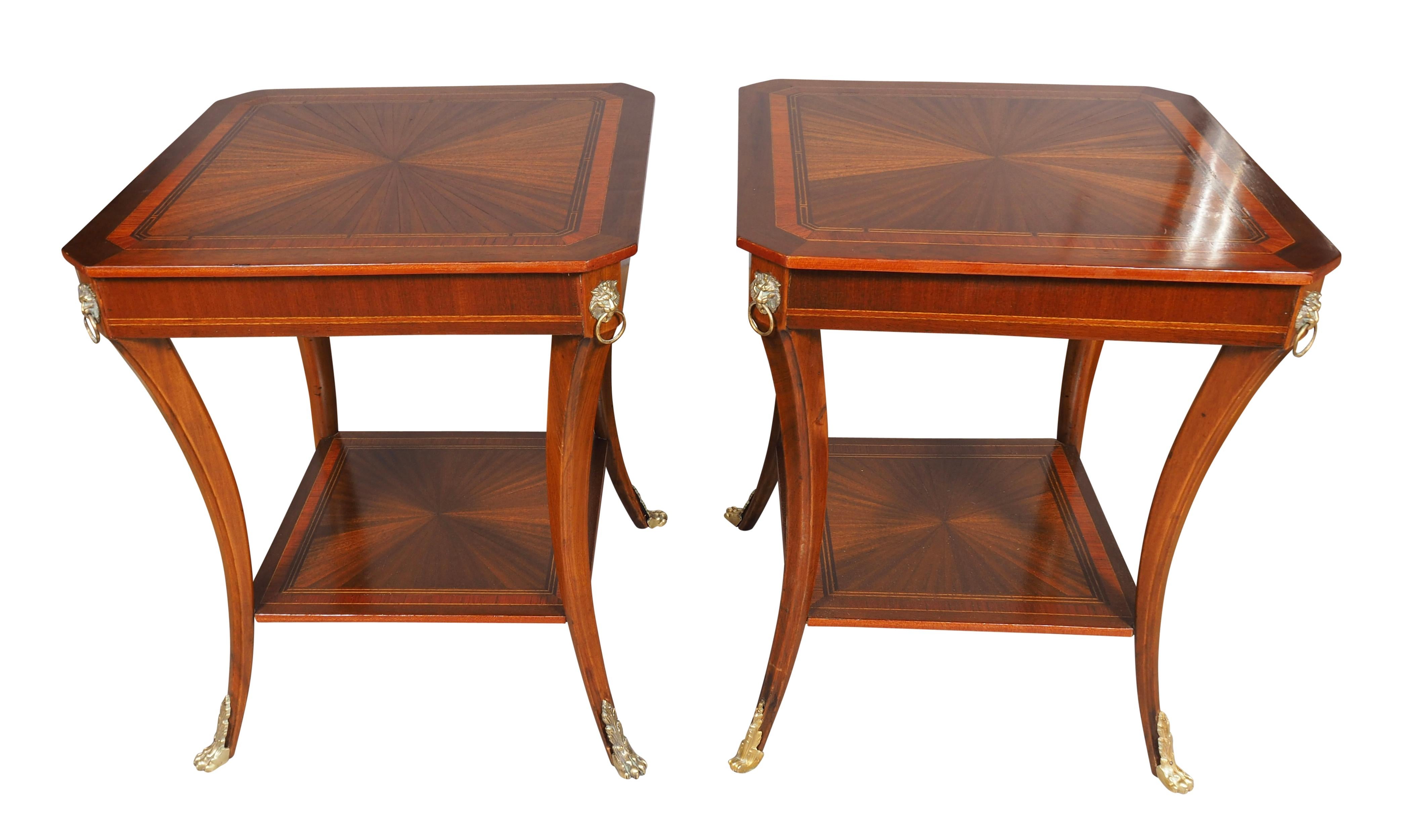 Square tops with chamfered corners and parquetry starburst design and a frieze with lions head ring handles and saber legs and lower shelf.