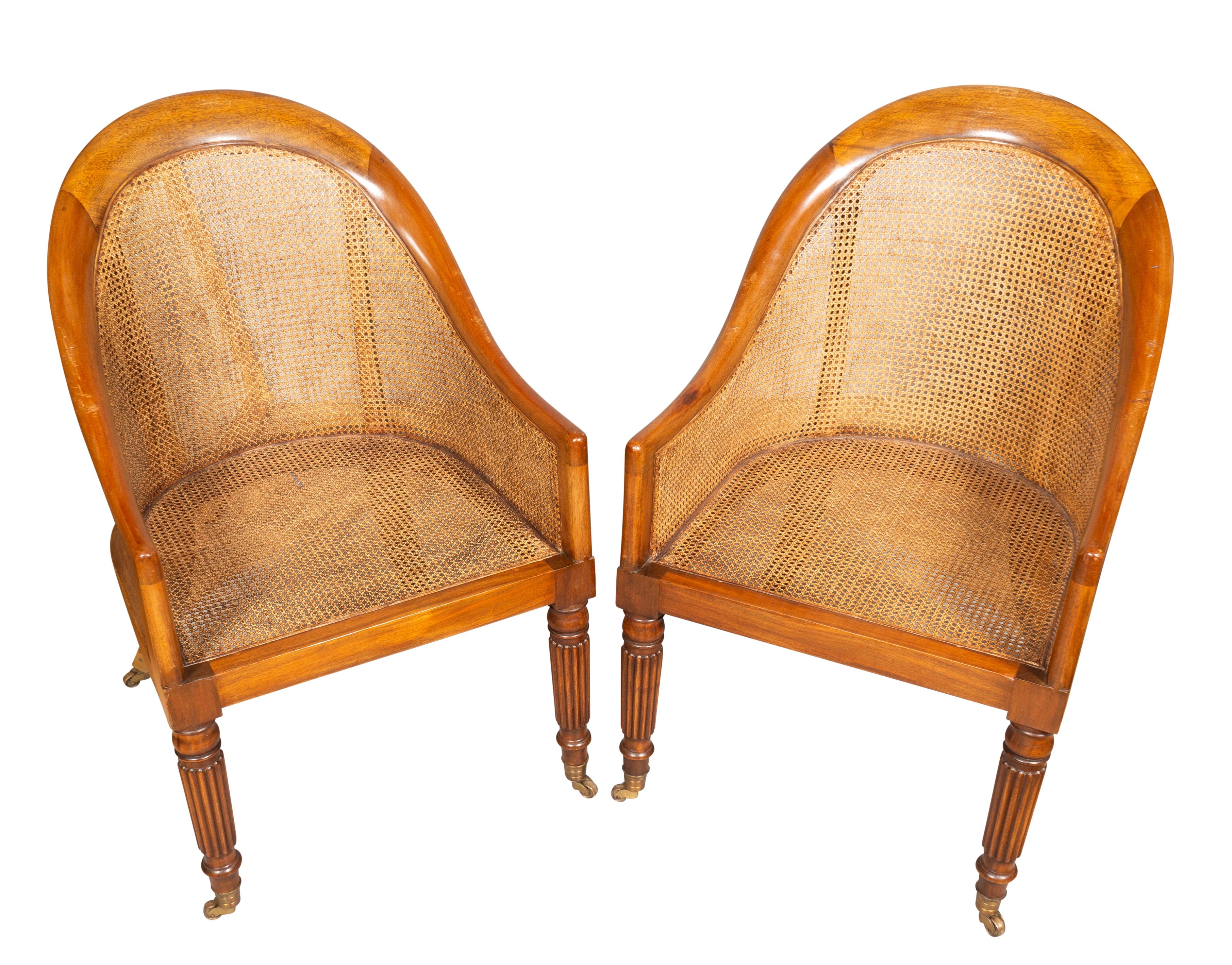 With an arched crest rail and caned back and down swept arms with caned sides , caned seat circular tapered reeded legs. Casters. Seat height without cushion 15.5 high.