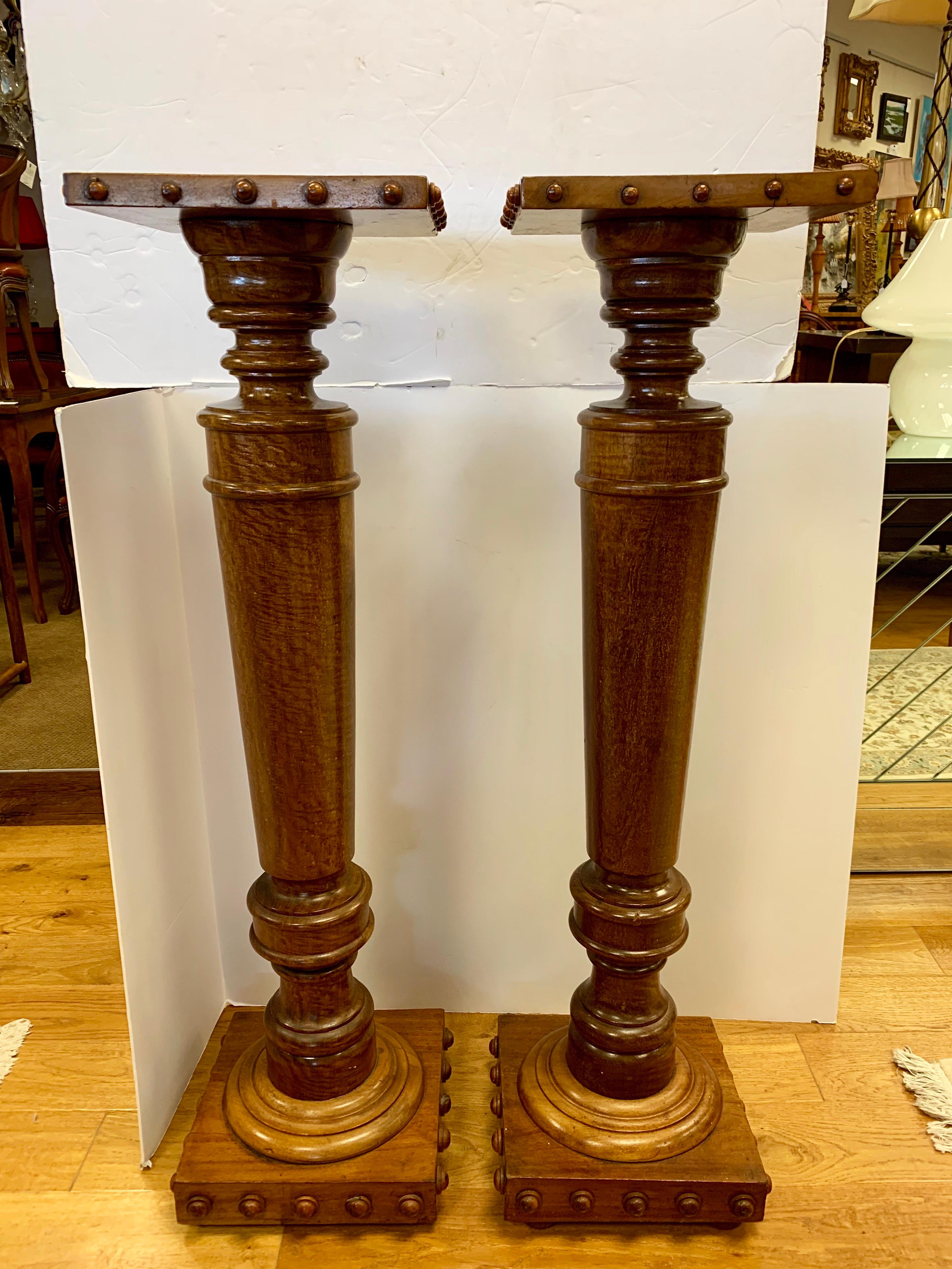 Pair of heavy Regency style mahogany column pedestals, the top is square, supported by tapered columns raised on a block plinth decorated with carved ball accents.