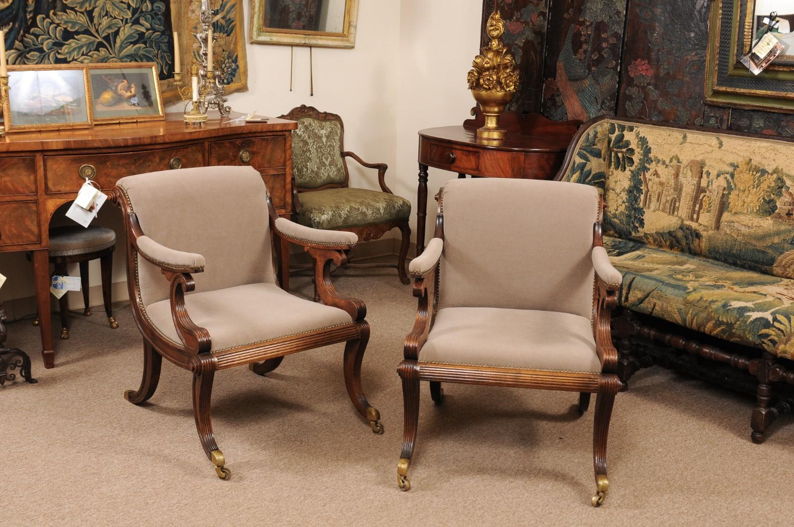 The pair of Regency style mahogany style upholstered armchairs with scroll backs and arms terminating in splayed legs with brass castors on front feet.



 