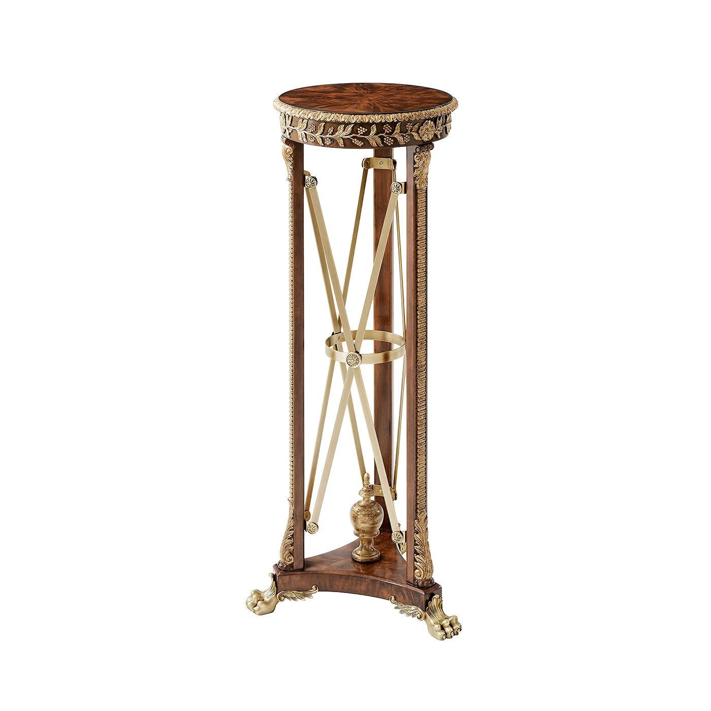 A fine pair of Regency style pedestals or carved and gilt torchères, the circular top with a carved edge and frieze, on three supports with acanthus bases and capitals, the whole supported on a trefoil concave base and raised on brass winged lions