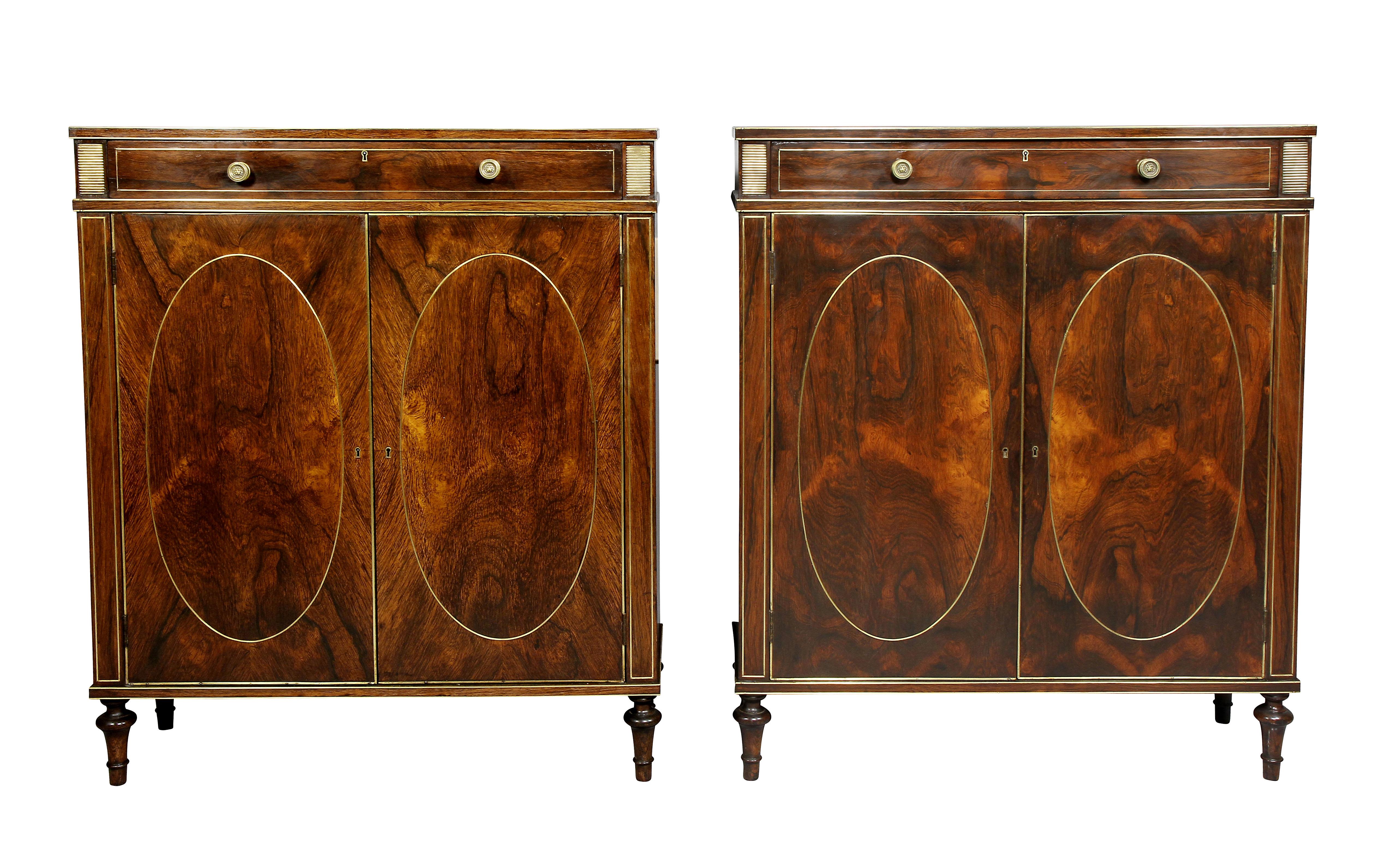 In the manner of John Mclean. Each with rectangular tops over a drawer flanked by brass grillwork panels above a pair of doors enclosing a shelf, raised on turned toupie legs. Casework with extensive brass work trim.