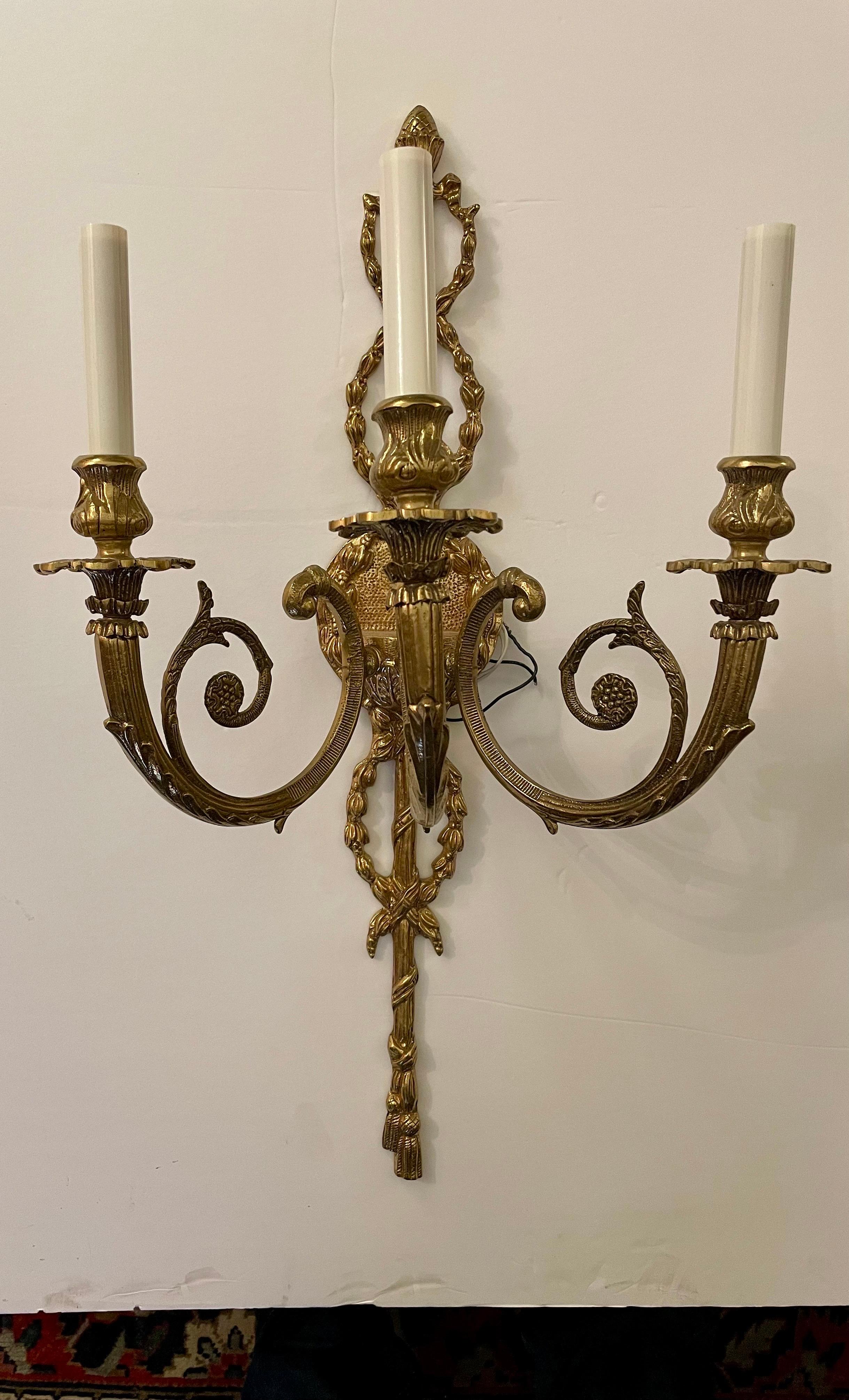 Pair of large scale Regency Style three arm brass Sconces. Wired and ready to use. New cream colored candle covers.