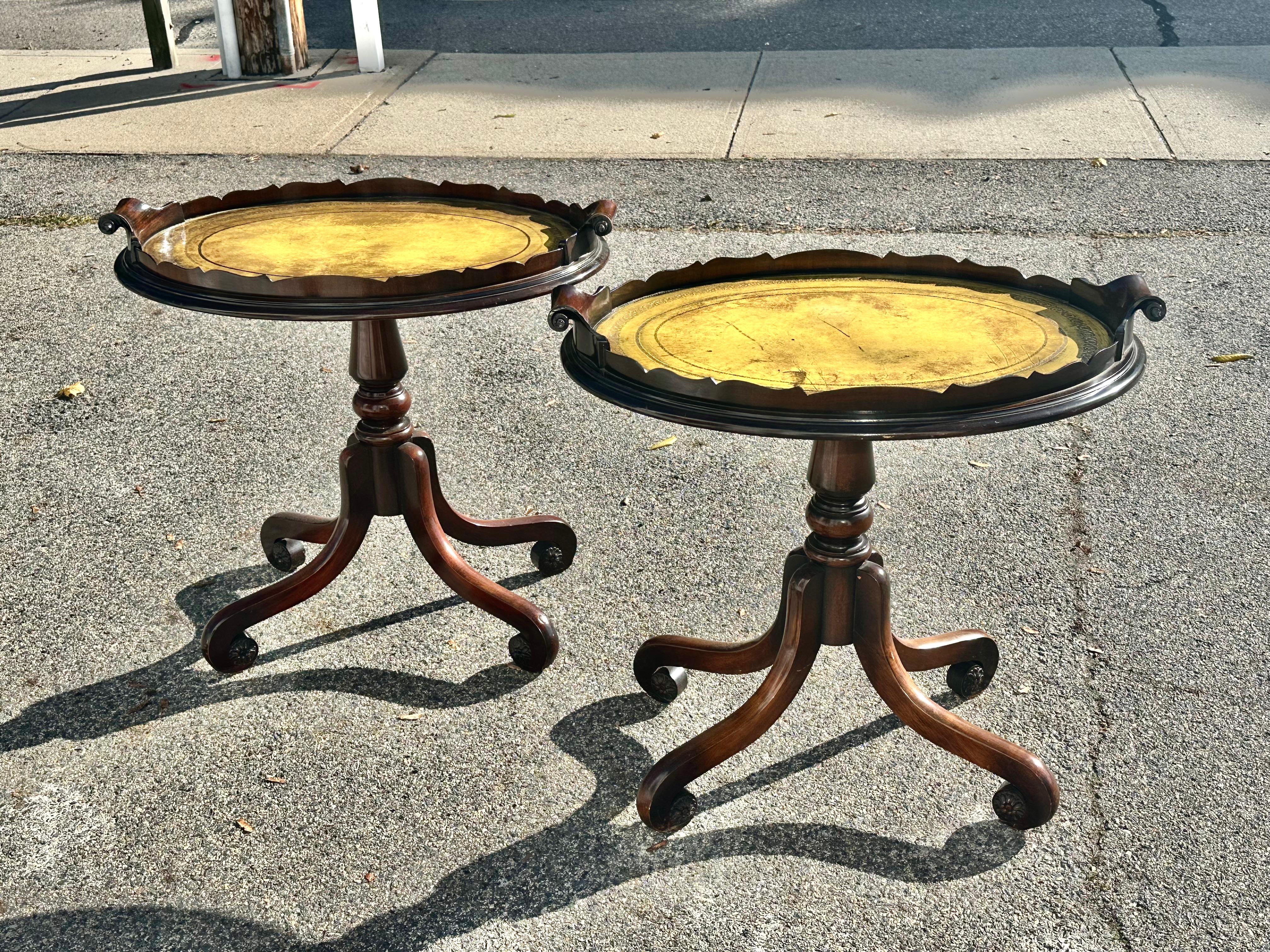 Pair of Chic Regency Style or Hollywood Regency Tray Top Side Tables.  Trays Top attached to Mahogany Bases with Four Turned over Legs Ending in Rosettes.  Trays with original yellow embossed leather.  Beautiful Edging and Scroll Handles.

Trays do