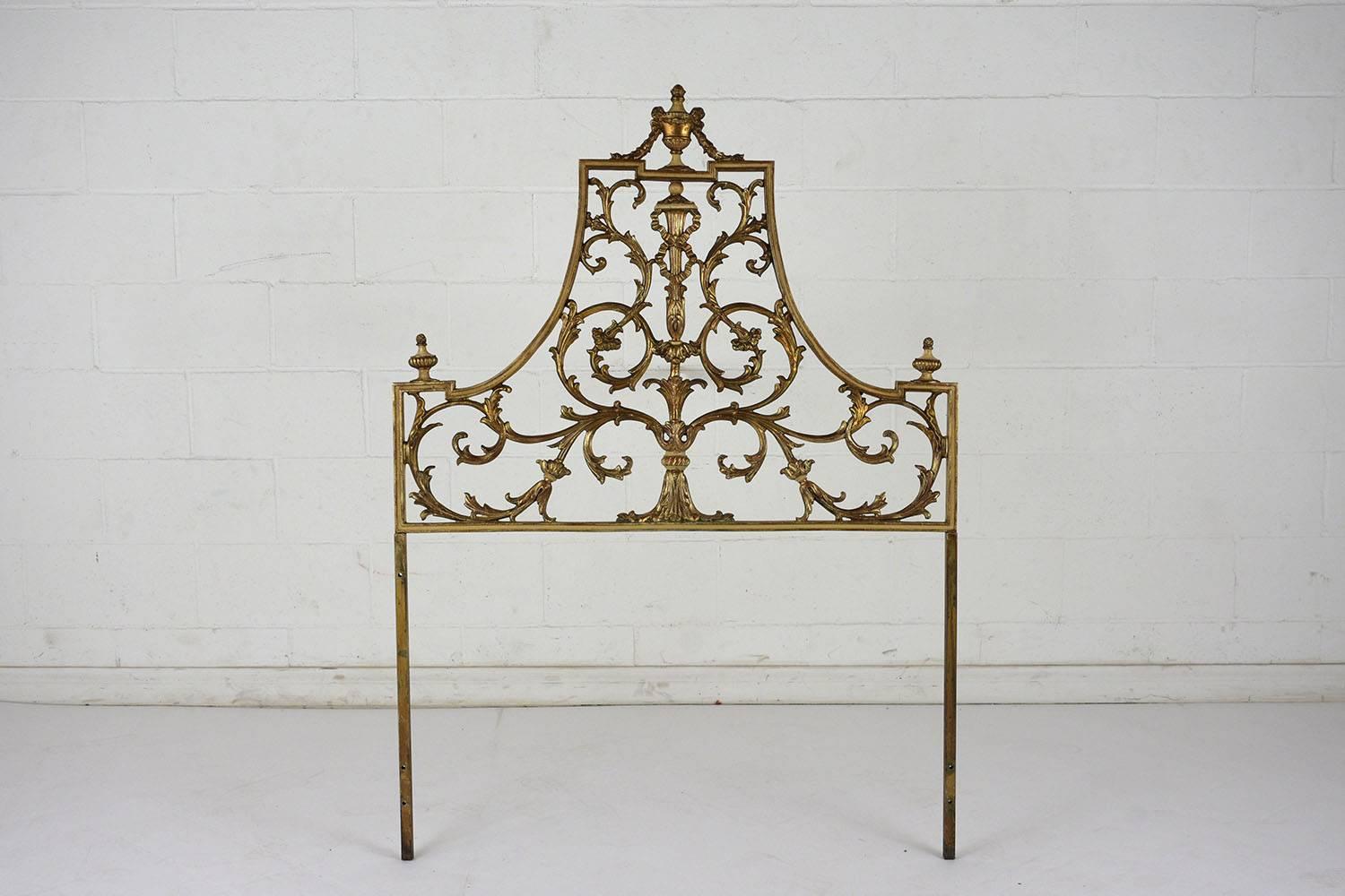 This pair of 1950s Regency style twin headboards are made of metal finished in an eye-catching gold color. The canopy shape of the headboards is accented by scrolling acanthus leaves and an elongated urn in the centre. The top and corners have