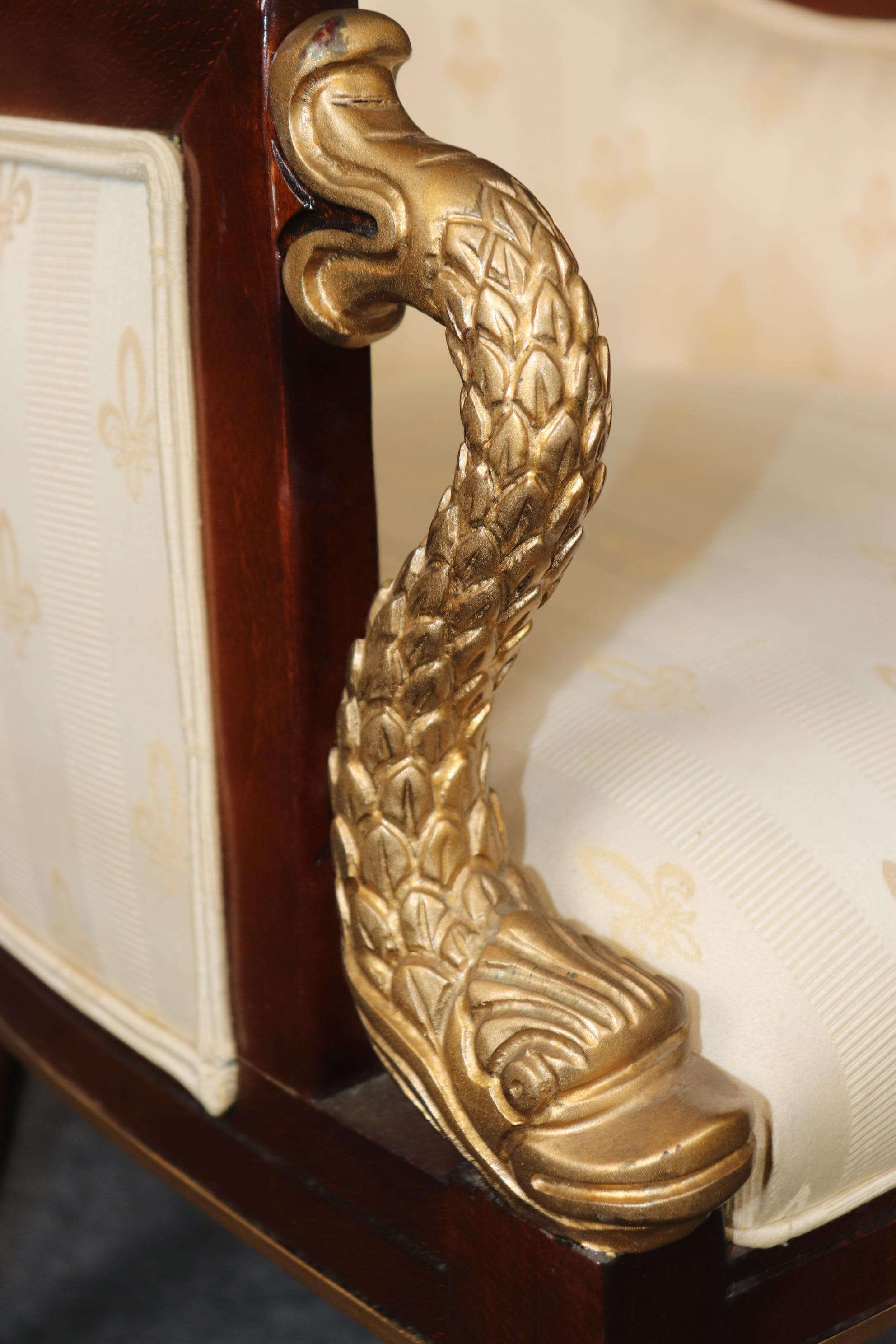This is a fantastic pair of gilded and mahogany chairs done in the regency style. The chairs are in good original condition and may show minor signs of age and use on upholstery, but the frames are clean and in good condition. They date to the 2000s