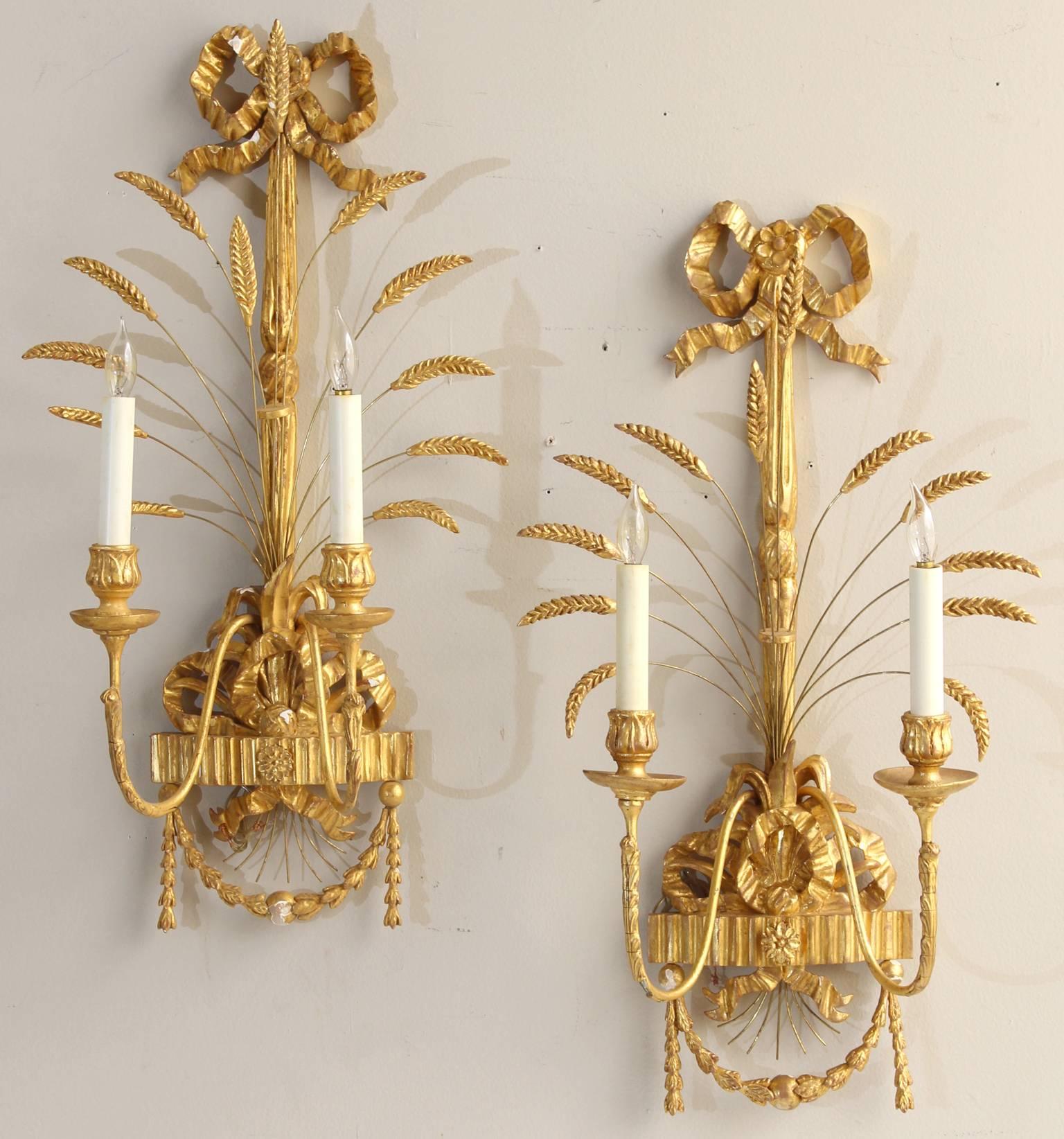 An elegant pair of Regency style carved wood and water gilt sconces wired for electricity.  