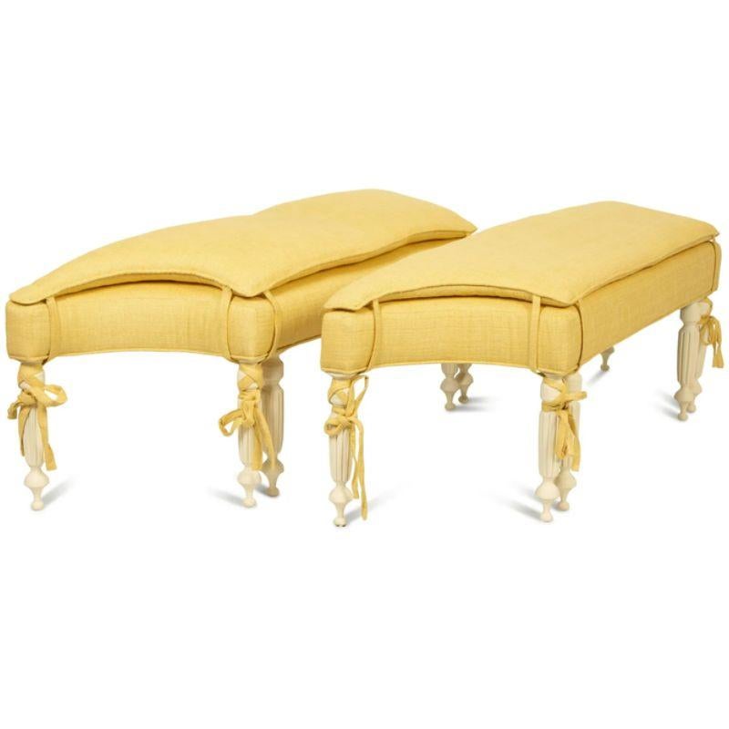 A vintage pair of Regency style yellow linen upholstered white painted shaped benches with double cushion and ties to legs