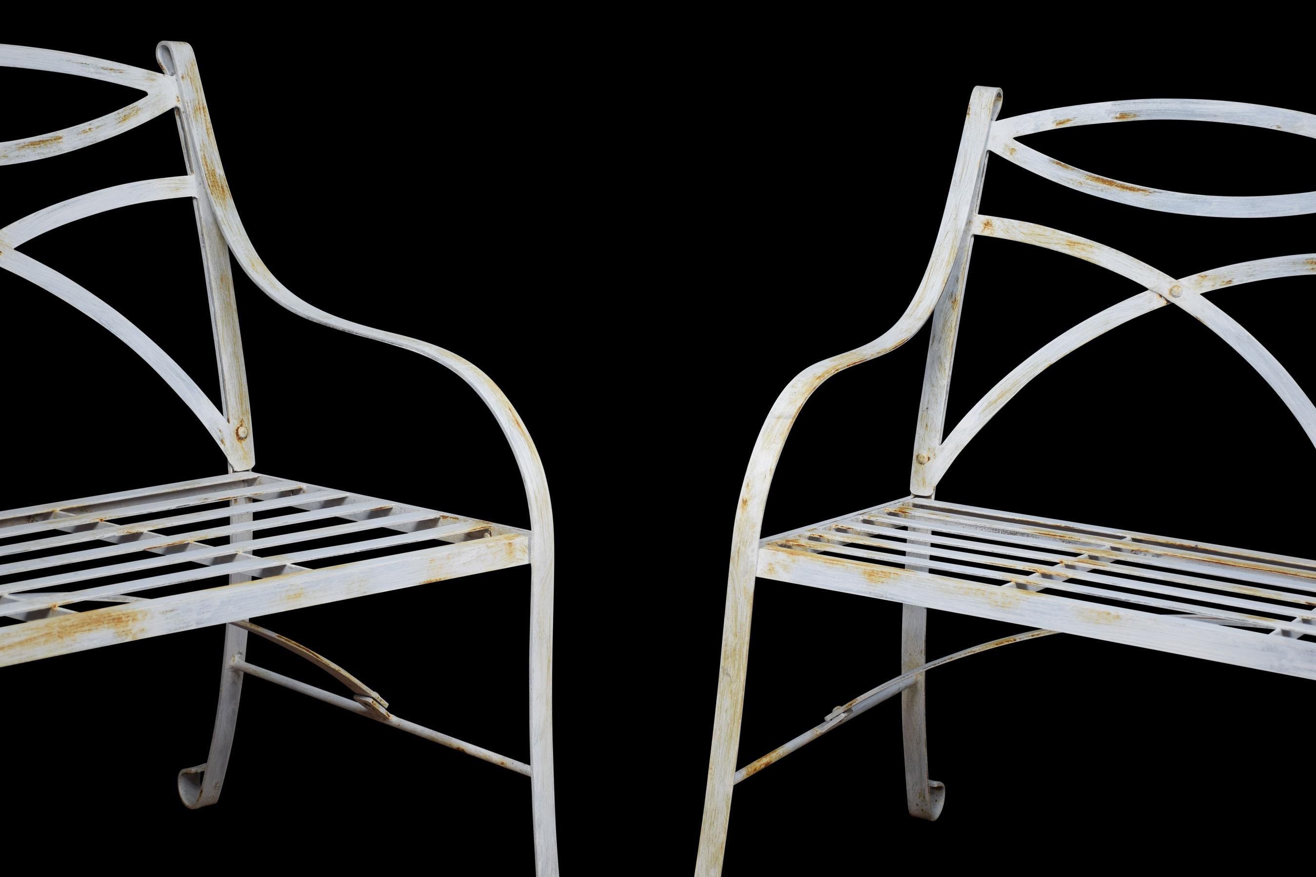 Pair of white painted metal garden benches with curved lattice backs and slatted seats raised up on shaped legs terminating in scrolling toes.
Dimensions:
Height 34.5 inches height to seat 18 inches
Width 43 inches
Depth 28 inches.