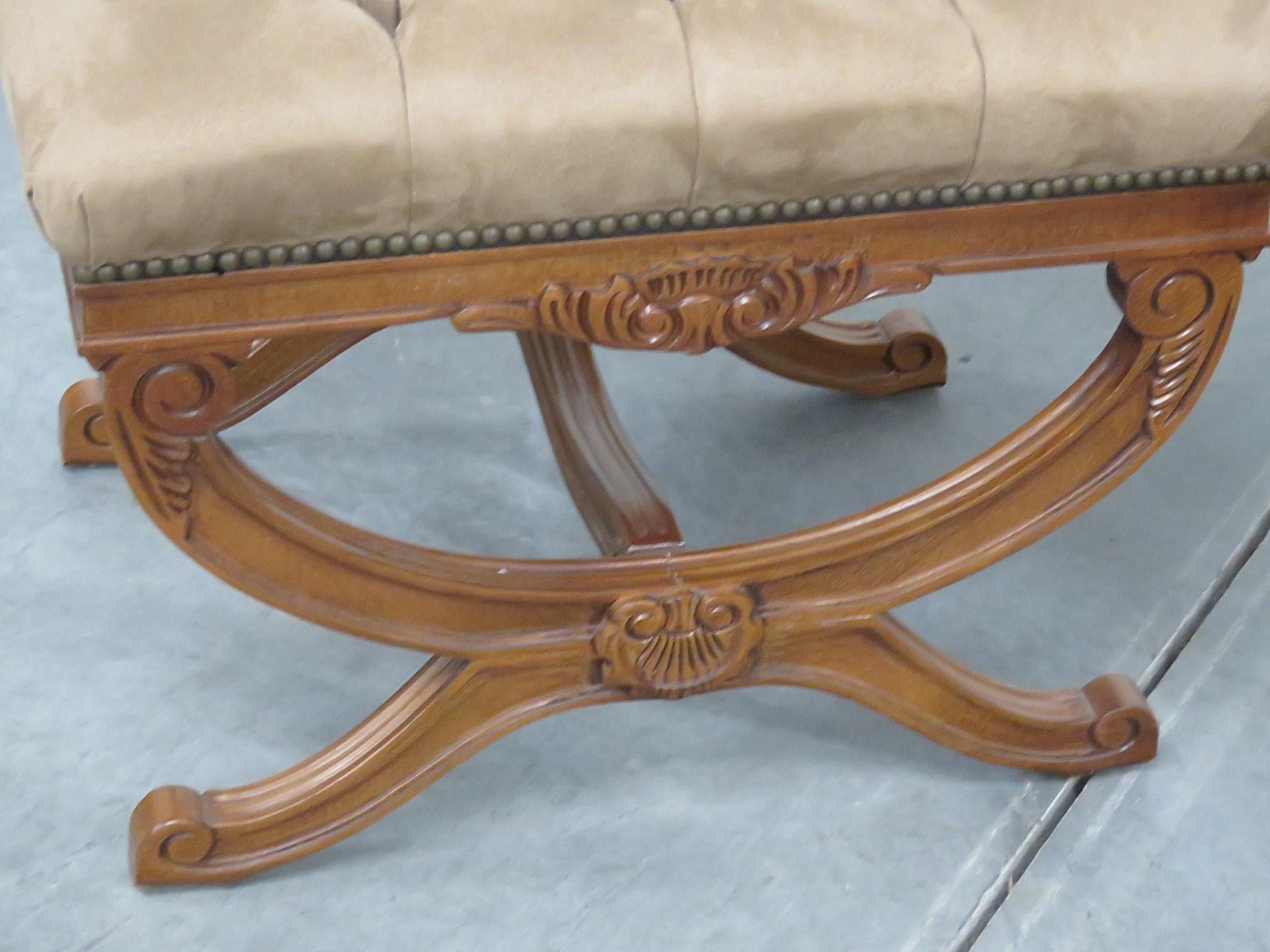 Pair of Regency style carved wood X benches with tufted upholstery and nailhead trim.