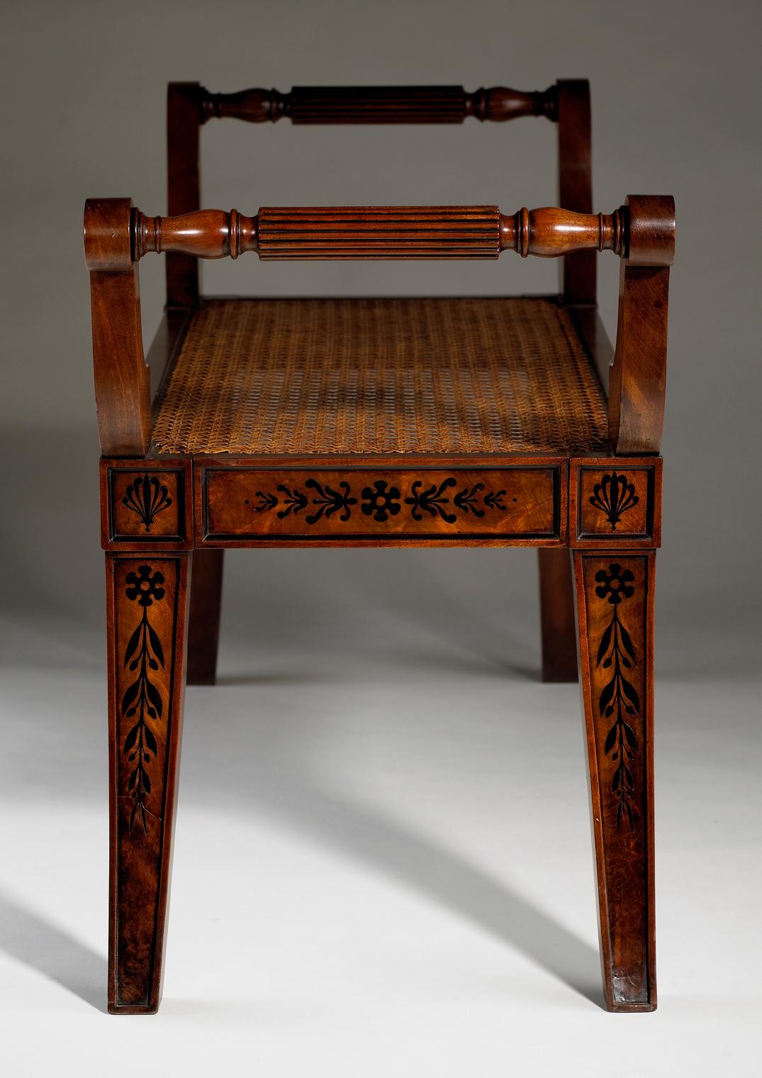 Pair of early 19th century neo Etruscan mahogany window seats with scroll arms, and sabre legs, the flat side panels with black banding and inlaid with anthemions and paterae, stylised foliate details, husks and dots. The seats with recent caning