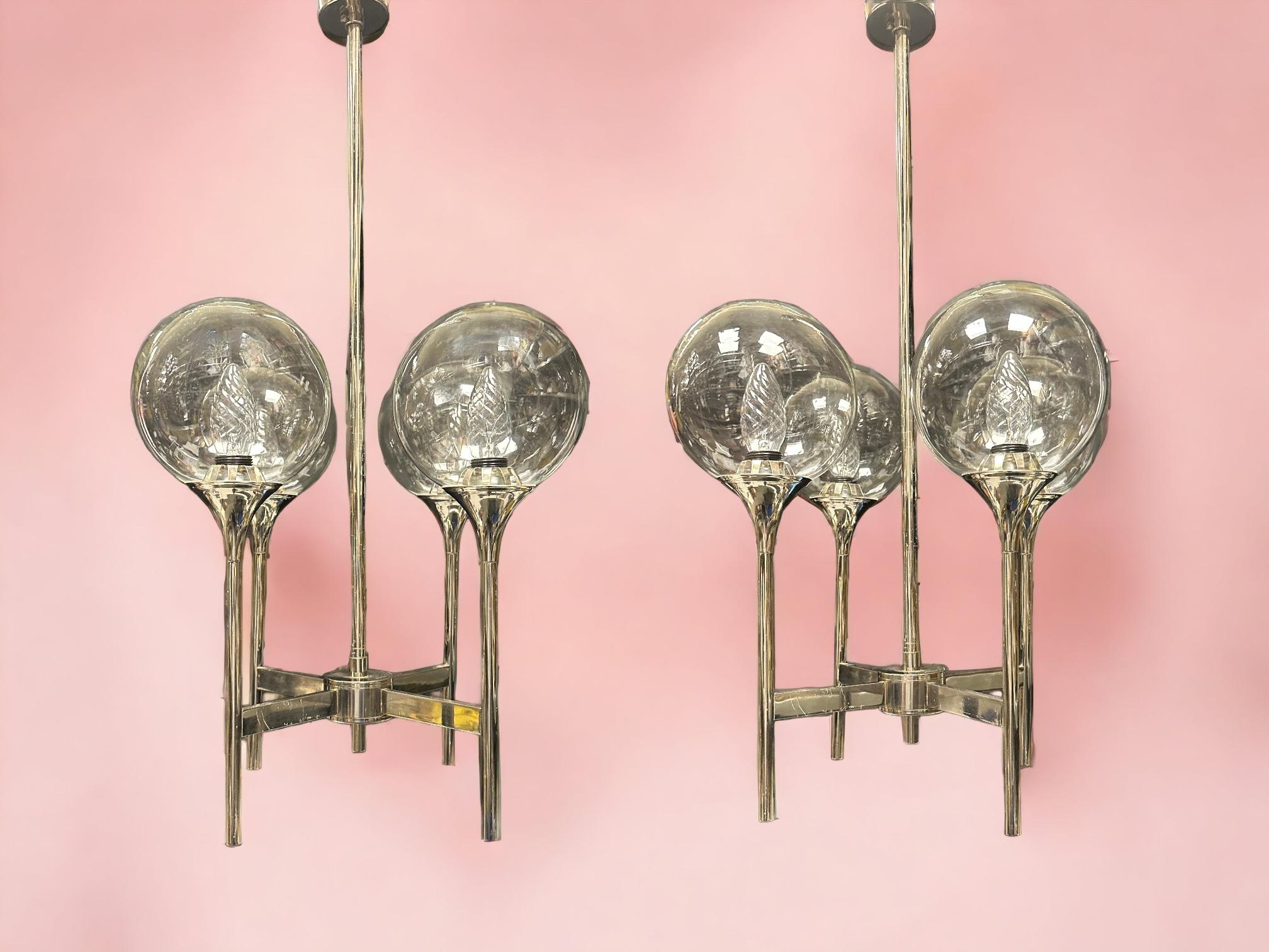 Ensemble de deux lampes à trompette chromées à quatre bras, de style Reggiani/Sciolari, datant des années 1970. Très rare et difficile à trouver en paire. Fabriqué probablement en Italie, années 1970. Chaque lustre nécessite quatre ampoules
