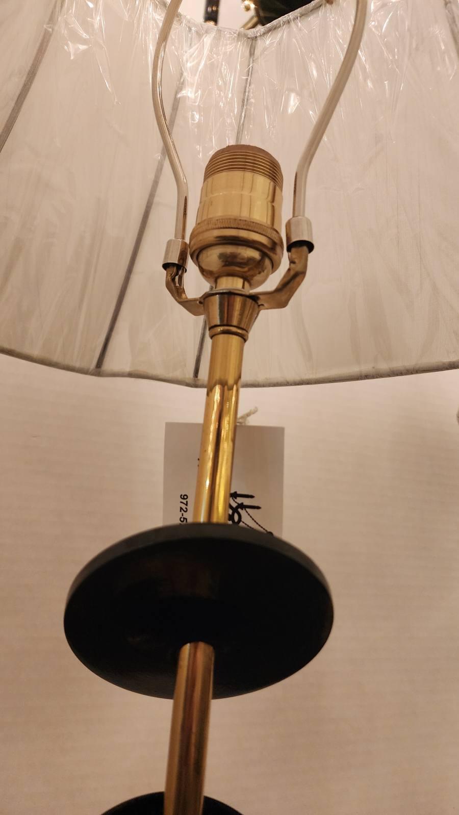 Questa inserzione presenta una coppia di lampade da tavolo Rembrandt di metà secolo, dallo stile molto moderno con una base in ottone e dischi acrilici neri che spezzano l'ottone senza soluzione di continuità. Il paralume non è originale, è stato