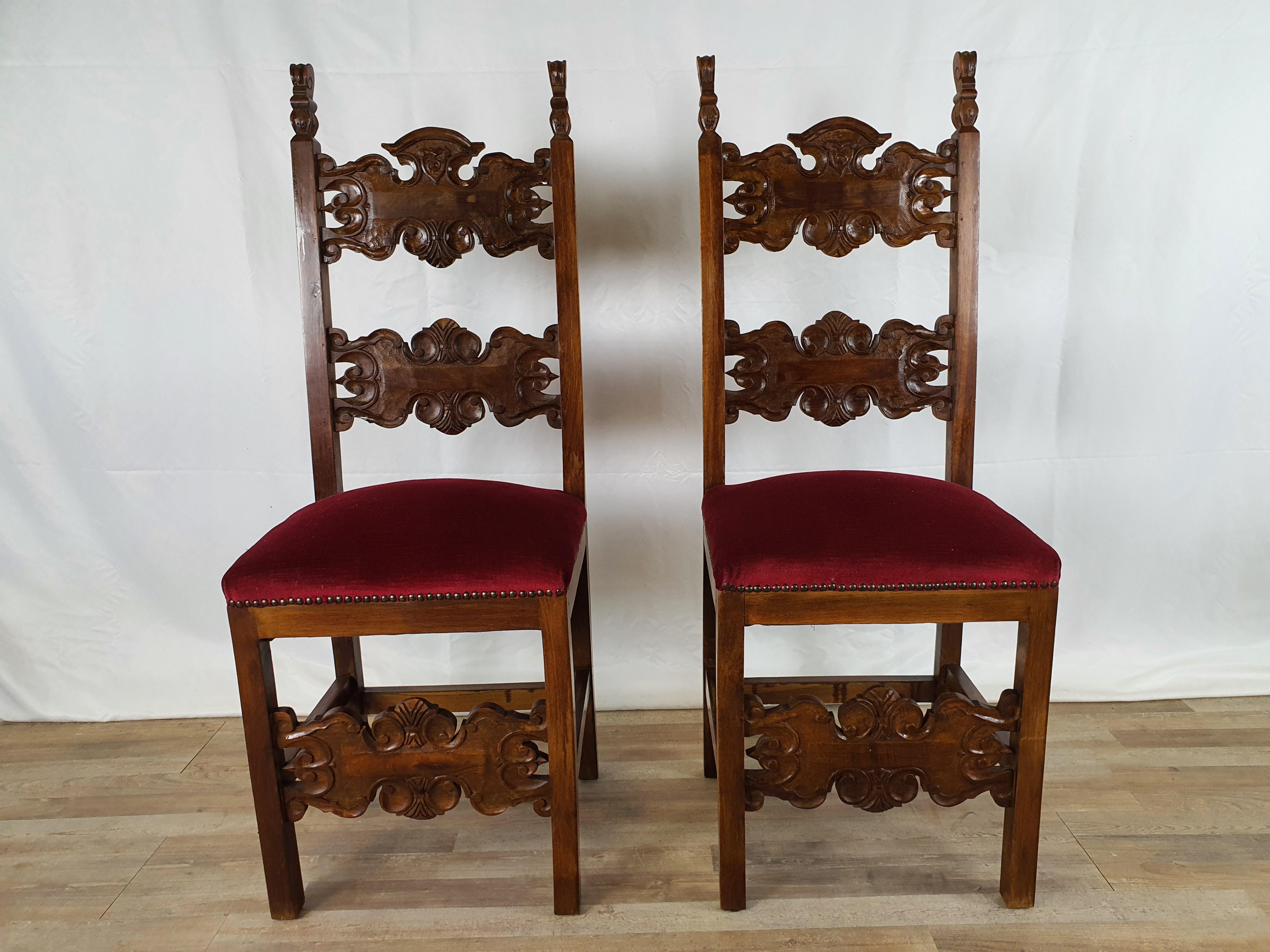 Pair of Renaissance style walnut chairs from the early 1900s, entirely in wood with seat upholstered in red fabric and outlined by small studs.

The chairs lend themselves well to dining rooms or even to be used as furnishing elements to enrich