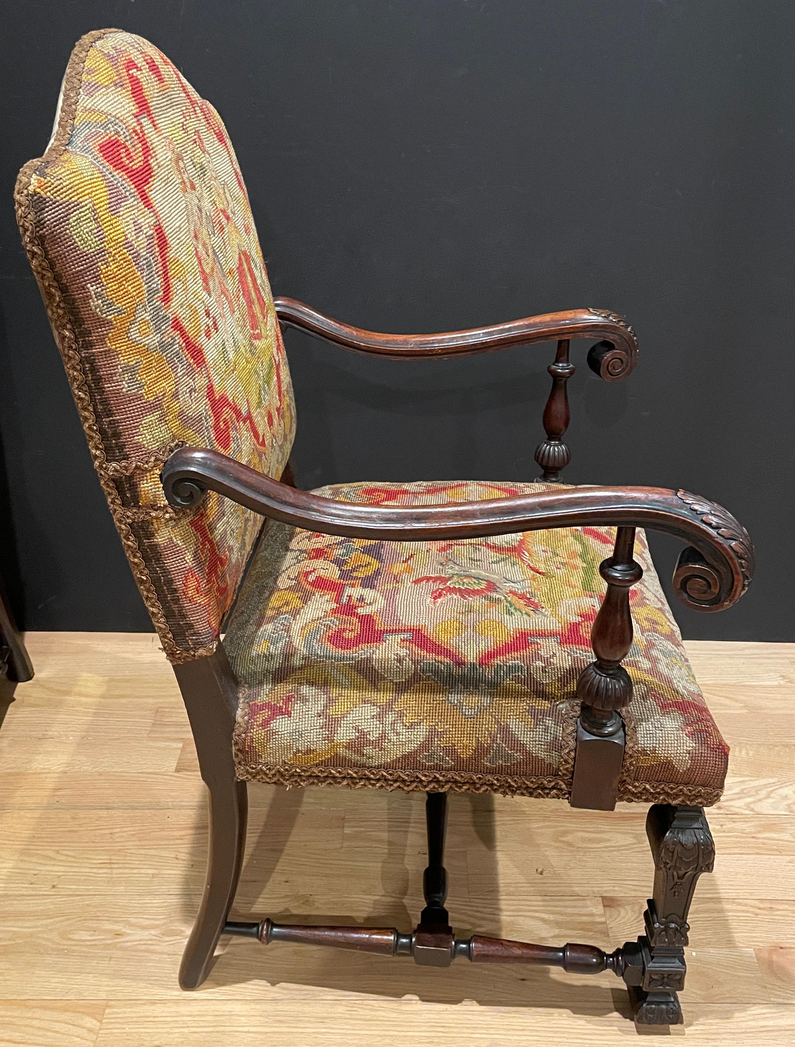 19th century carved walnut Renaissance Revival petit-point tapestry upholstered carved arm chairs. Original petit point tapestry seat and back. Different scenes on all four panels featuring musical and romantic scenes on backs and scenes with birds