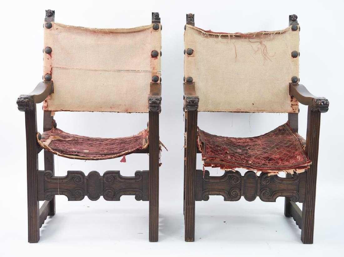 The pair of Renaissance-style throne or hall chairs have hand carved masks at the tops of the backs, all four are different with faces representing all ages. Hand carved lion faces embellish the ends of the arms while stop fluting runs the lengths