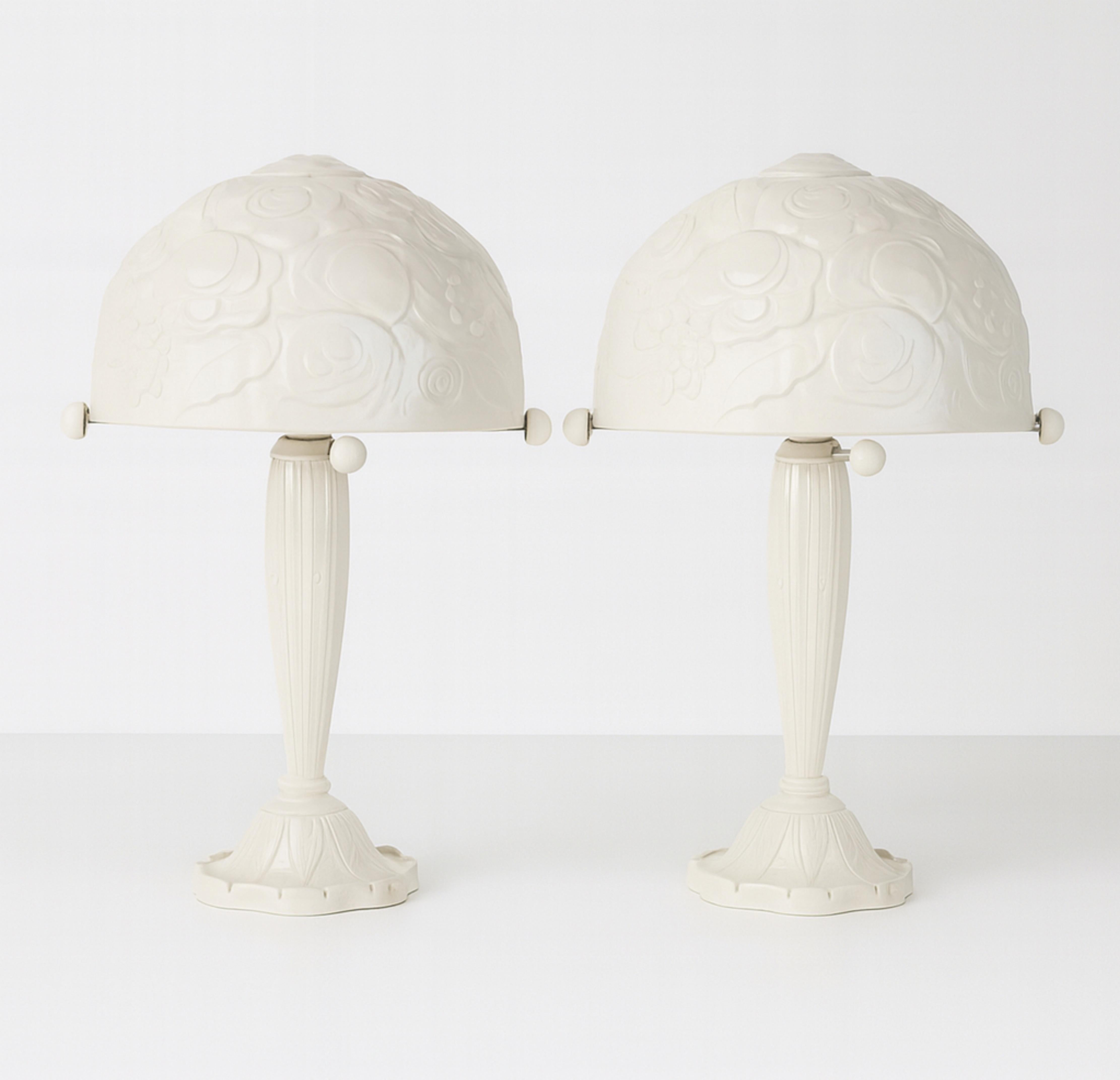 Dieses Paar Tischlampen in cremefarbenem Lack wurde im unverwechselbaren Stil von René Lalique nachgearbeitet, mit einem Briefkopf und einem gebürsteten Effekt auf der Struktur aus vernickeltem Messing.
Die geätzten Glasrosen setzen einen zarten