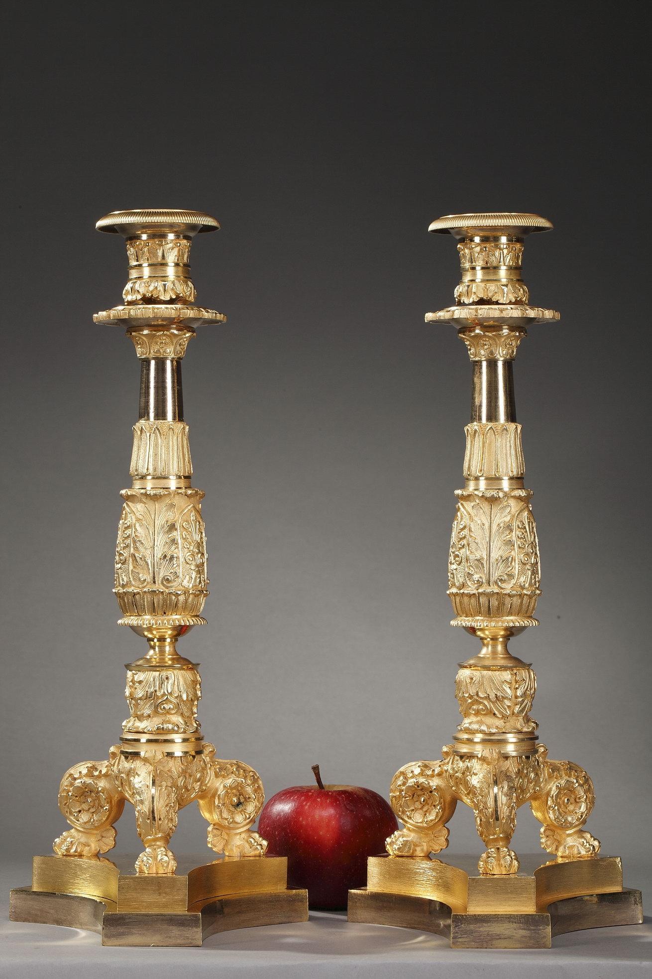 Pair of Restauration candlesticks crafted of gilt bronze, richly decorated with acanthus leaf, palmettes, scrolls, water-leaf and flowers. Each candlestick rests on three foliated claw feet above a tripod base with chamfered angles,

circa