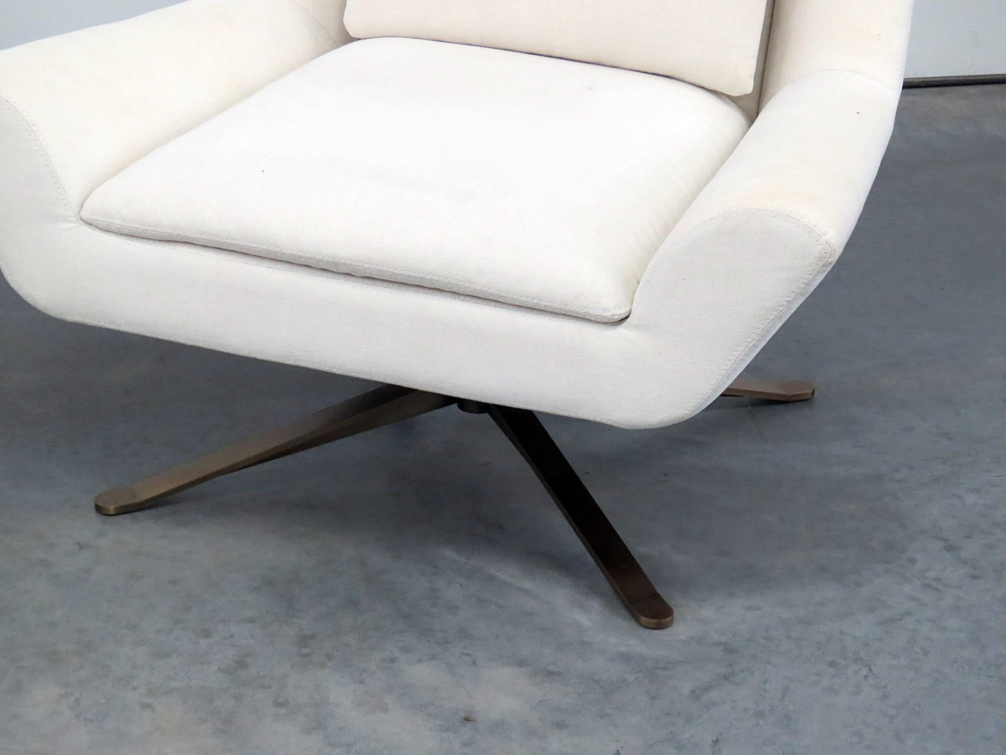 Pair of Restoration Hardware Luke swivel chairs on burnished bronze colored bases with countoured backs, flared arms and lumbar pillows.