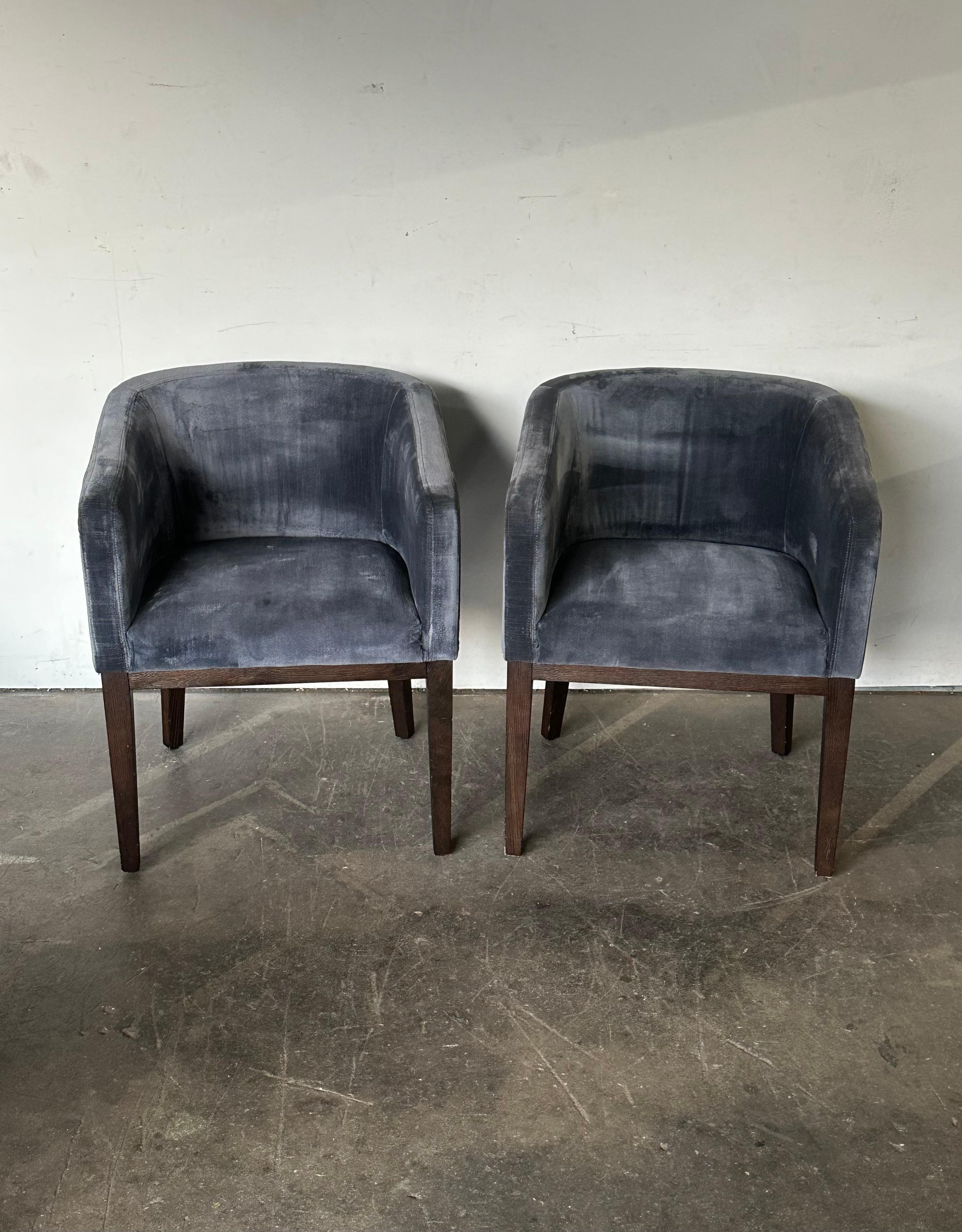 Pair of elegant Morgan Barrelback armchairs by Restoration Hardware. Efficient clean minimalist design, executed in indigo velvet and ebonized frame. In good condition with normal signs of use. Upholstery has been cleaned, wood has been cleaned and