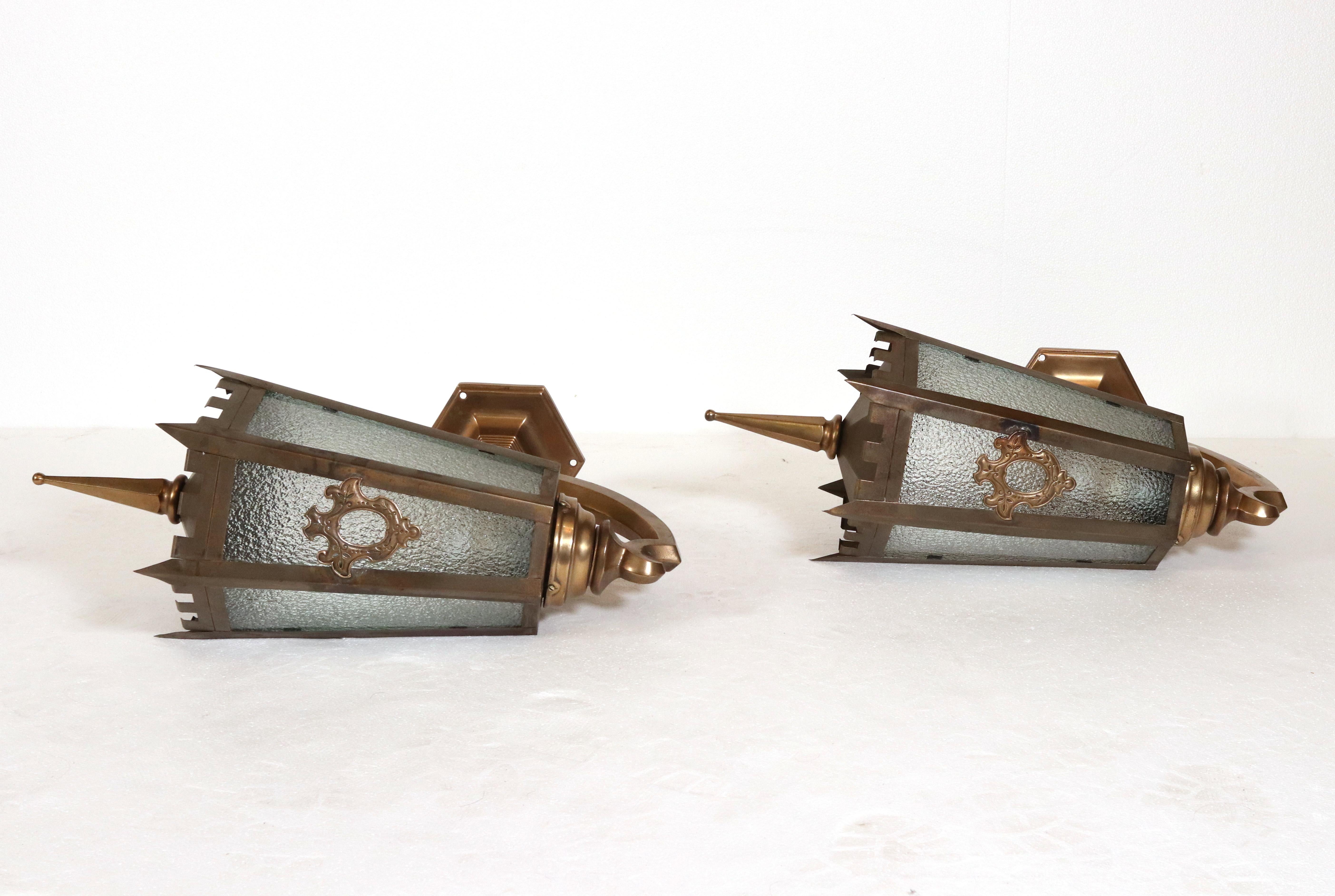 Ein Paar Außenleuchten aus patiniertem Messing und Bronzeguss mit klarem, strukturiertem Glas. Beide wurden gereinigt und neu verkabelt und sind in einem guten Zustand und bereit zum Versand. Der Preis gilt für ein Paar. Gereinigt und restauriert.