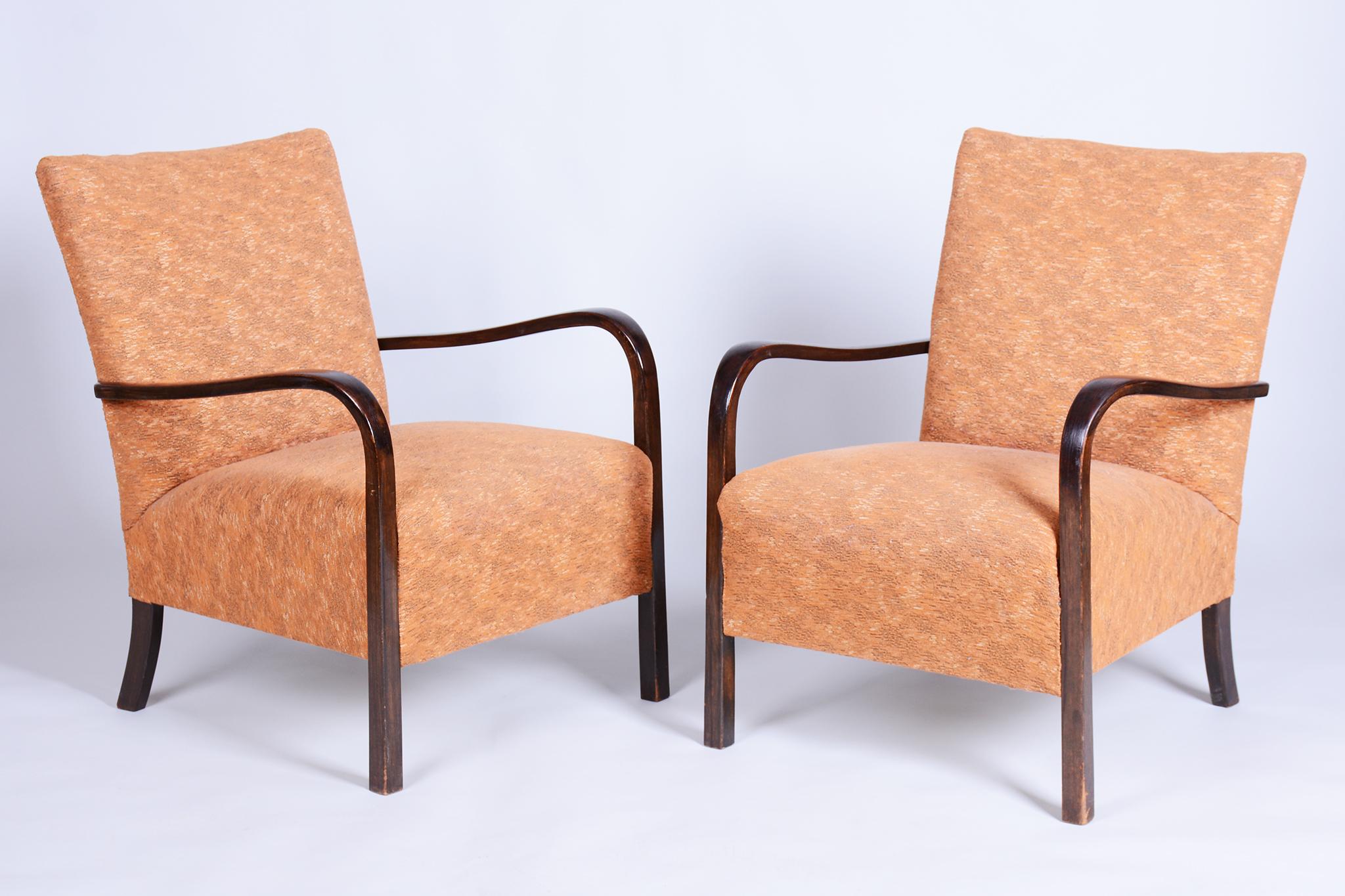 Questa elegante coppia di poltrone Art Déco proviene dalla Cecoslovacchia degli anni '30 ed è stata sottoposta a un accurato restauro. Presentano una stabile struttura in faggio massiccio e conservano la tradizionale imbottitura a molle originale in