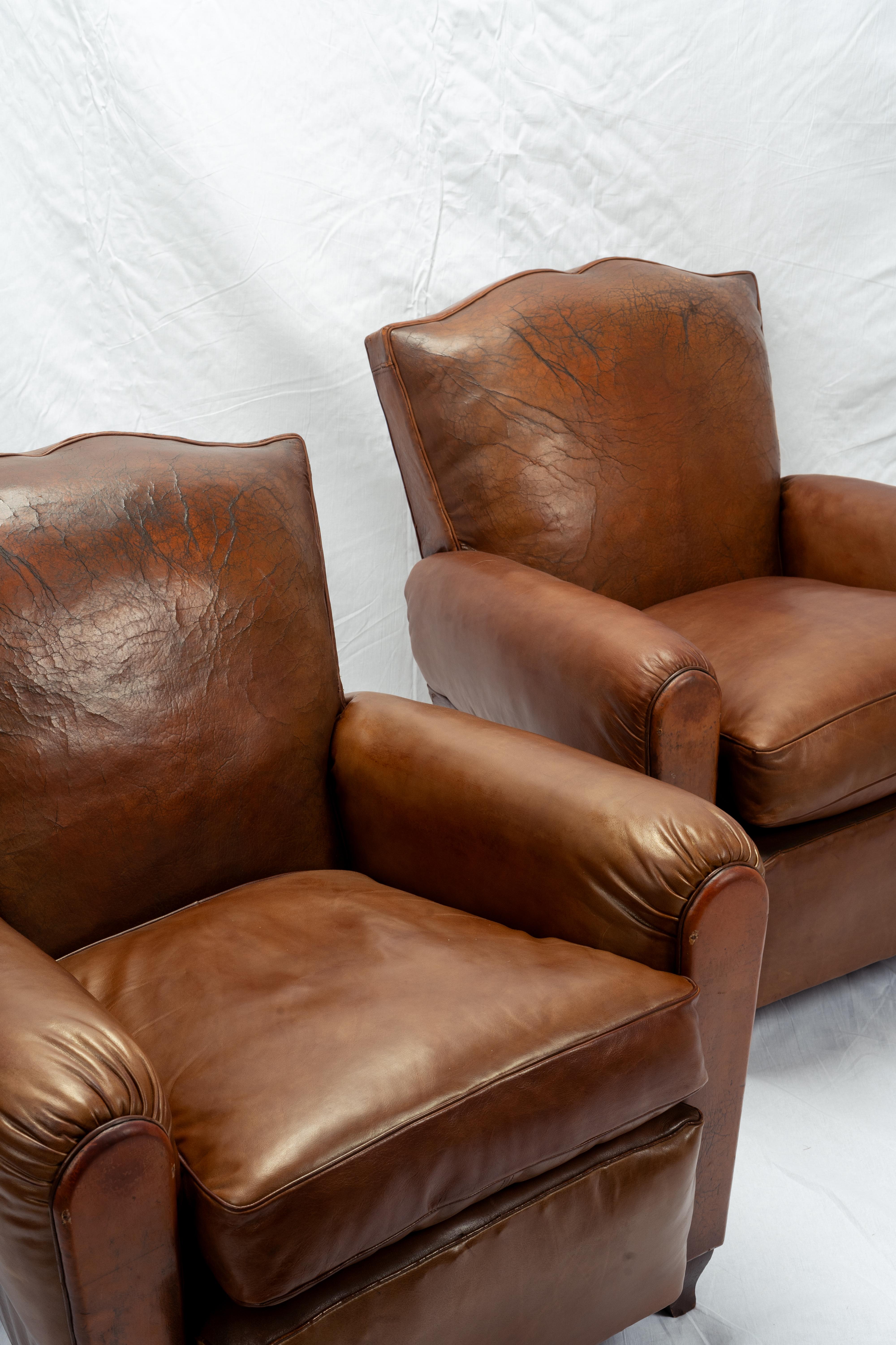 Referred to by collectors as the 'mustache' chair, owed in full by the silhouette of its backrest, this pair of remarkably rare and equally beautiful aniline leather club chairs were crafted in Paris, sometime in the 1930s or 1940s.

These chairs