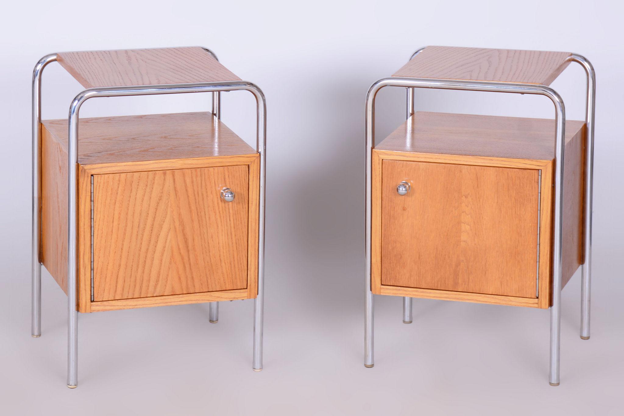 Este par de mesillas de noche de principios del siglo XX es un ejemplo excepcional del diseño funcionalista de la Bauhaus. Fabricadas en Checoslovaquia, combinan a la perfección el elegante acero cromado con la chapa de roble, creando una armoniosa