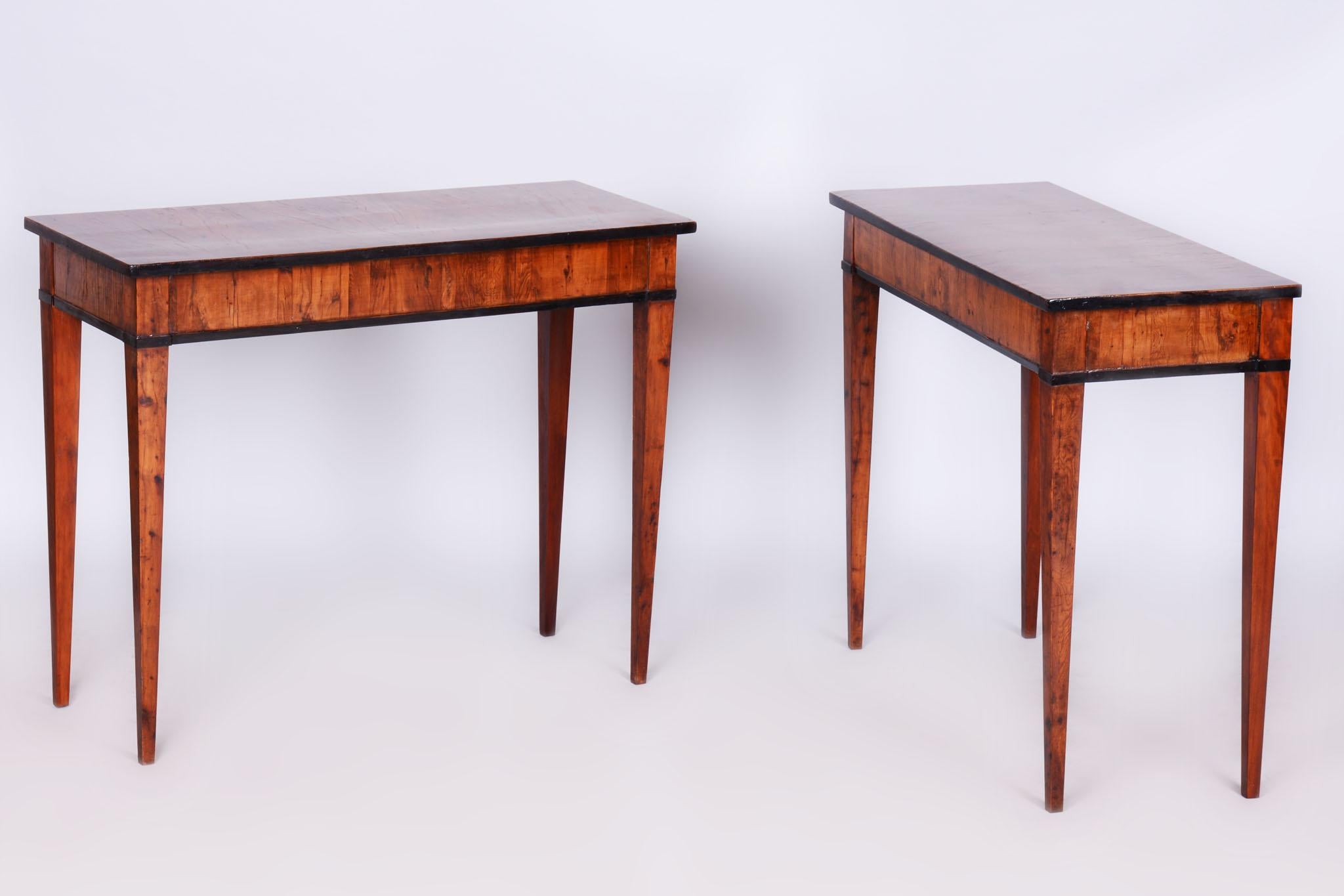 Dieses elegante, an der Grenze zwischen Empire und Biedermeier entworfene Konsolentischpaar stammt aus dem Österreich des frühen 19. Jahrhunderts. Sie sind aus Eibenfurnier gefertigt und wurden einer sorgfältigen Restaurierung unterzogen, bei der
