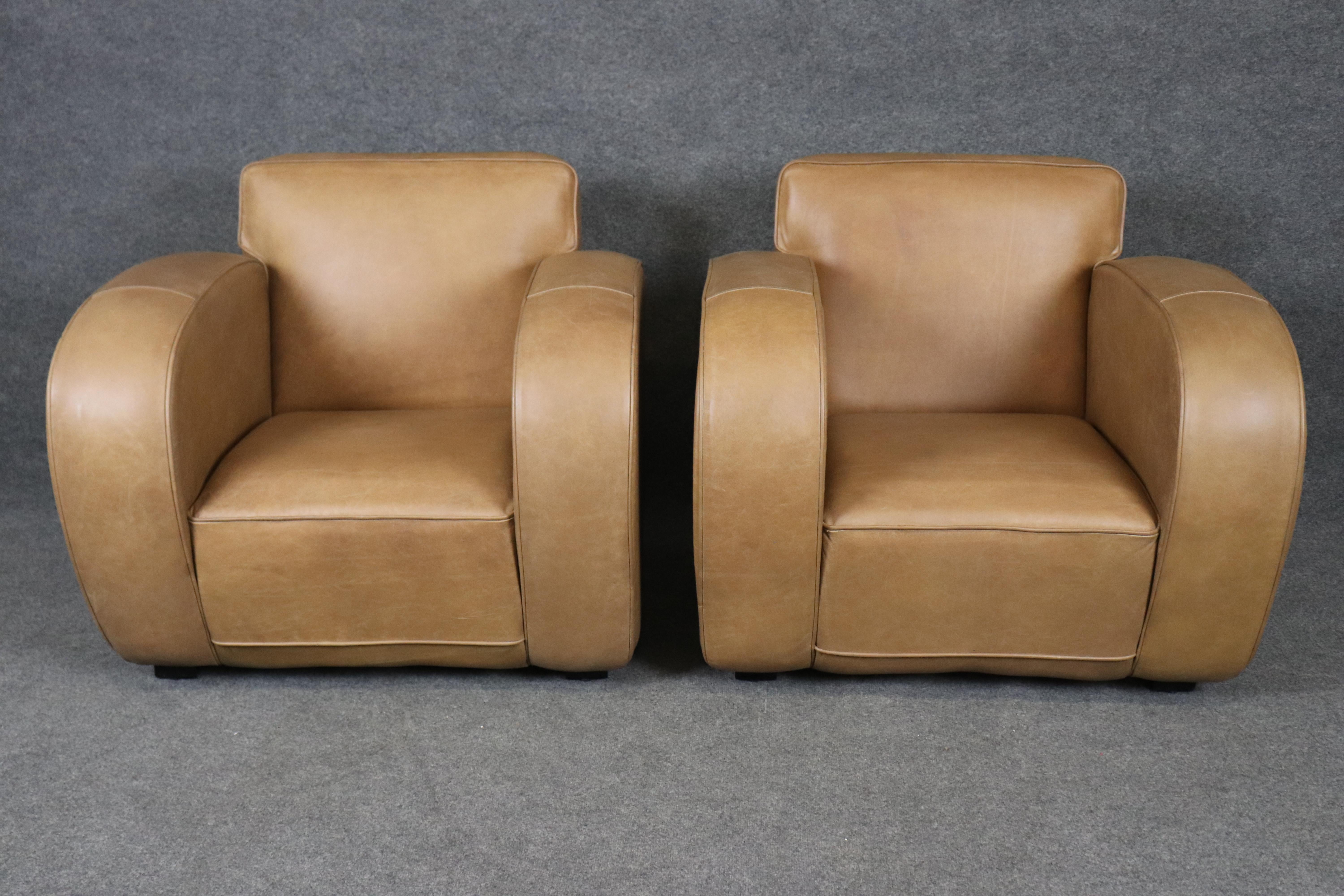 This outstanding pair of French Art Deco club chairs has been beautifully restored and upholstered in a warm tan distressed leather, capturing both the timeless spirit of the 1930s and the durability required for modern living. With their iconic