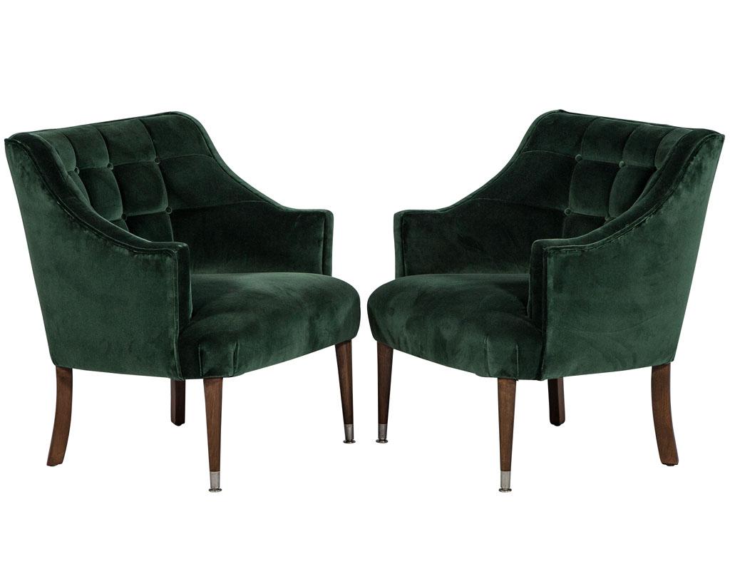 This pair of midcentury tufted lounge chairs, Newly reupholstered in an emerald green velvet designer fabric, with a curved back and tufted squares to add a sleek modern touch. A beautiful pair of chairs for an elegant living room.