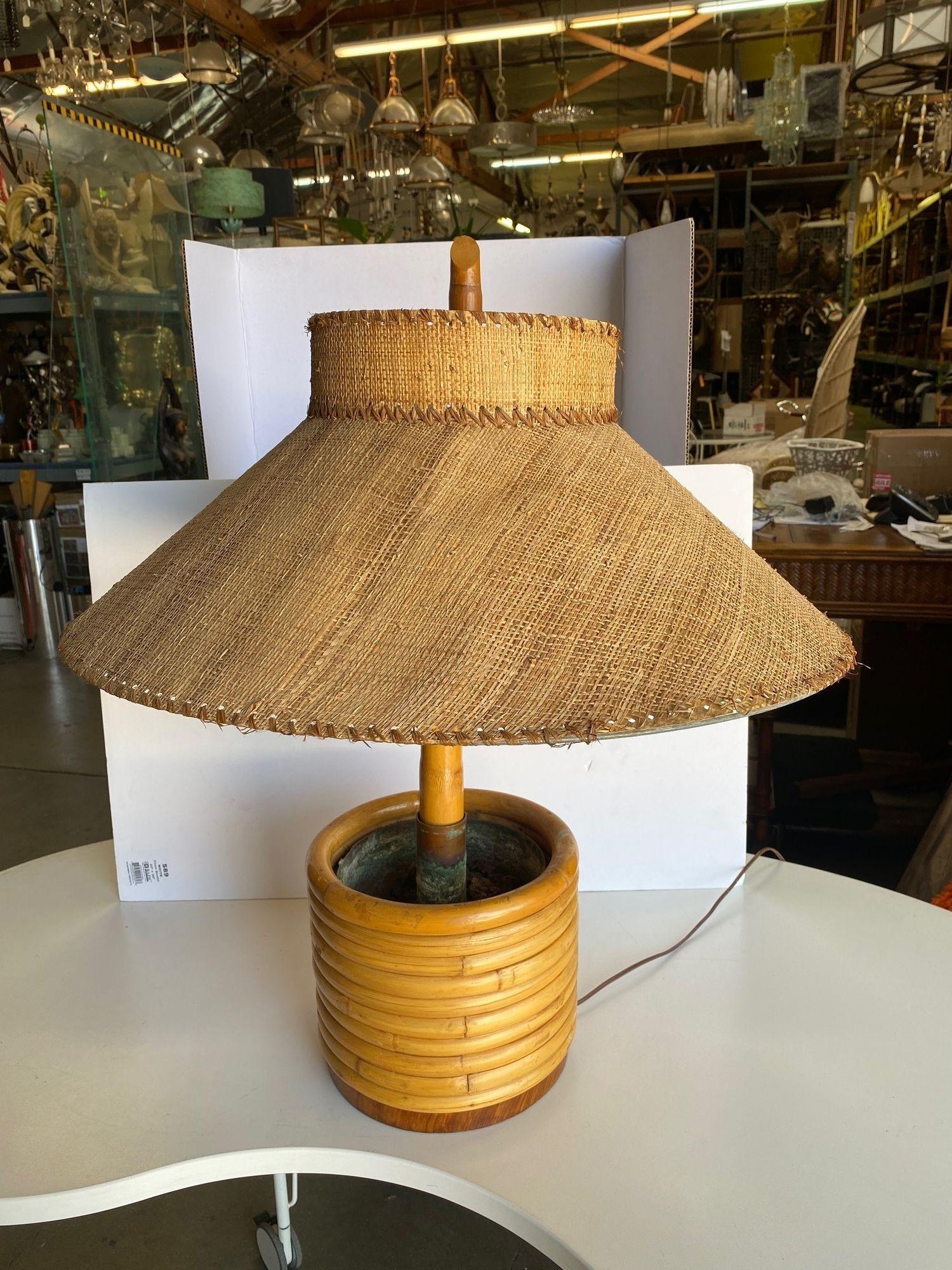 Pair of restored Mid-Century round stacked rattan rattan table lamps featuring 10 staked rattan poles stacked fixed to a mahogany round base, circa 1950. Measures 9.5