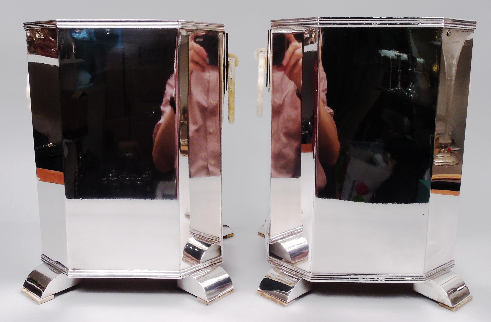 Pair of Retro Deco wine coolers. Straight sides and chamfered corners with splayed supports. Stepped triangular mounts with loose rings. Bears marks. 