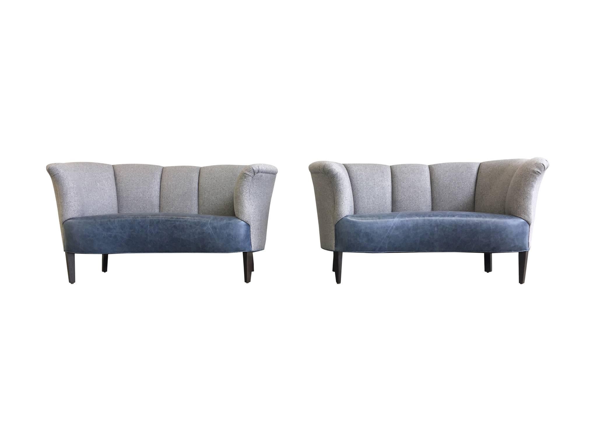 These mid-20th century Danish settees were originally designed by Slagelse Møbelvaerk. They are newly and completely reupholstered. The impeccable craftsmanship replaced the seats with marbleized blue Edelman leather, while the channel back and arms