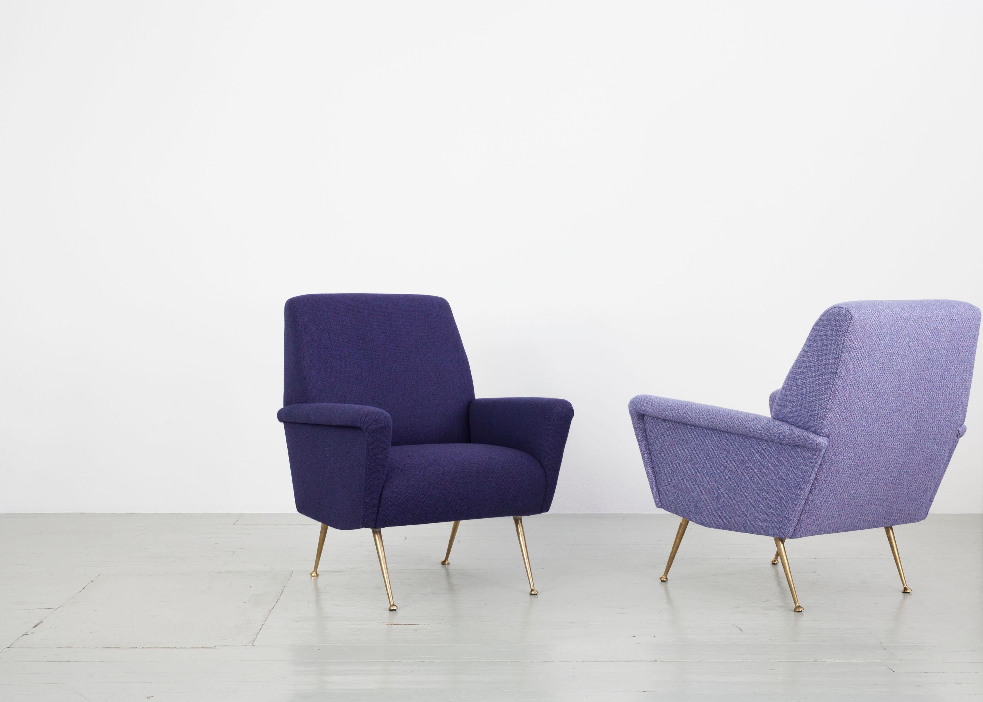 This pair of armchairs was made in Italy in the 1950s. Both pieces of furniture have been reupholstered with a woolen fabric by the Backhausen company in light and dark purple. The body is supported by thin, golden chair legs that show a slight