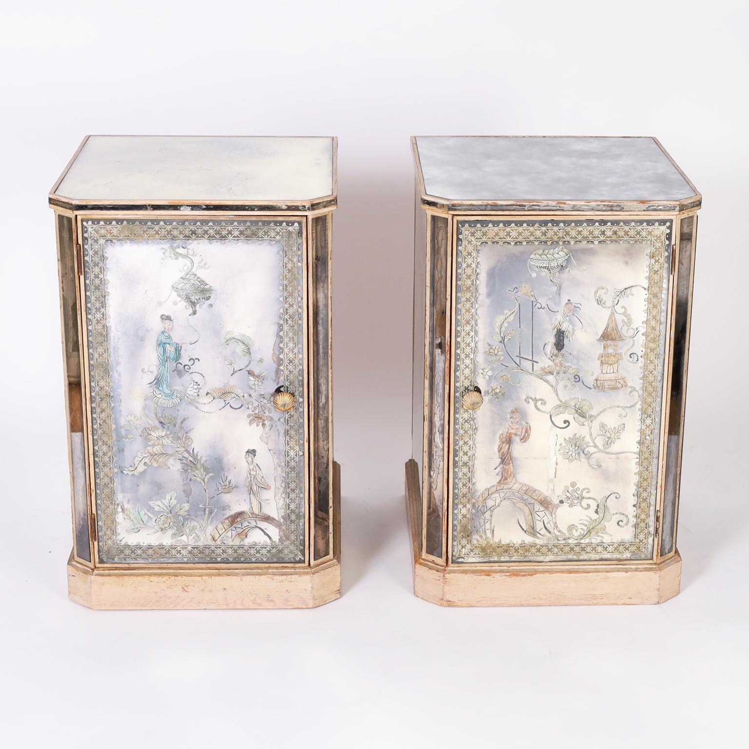 Pair of Italian art deco églomisé nightstands with distressed mirrored panels decorated in a reverse painting technique with chinoiserie designs on the fronts and three sides, one side replaced and two have small cracks. The doors have the original