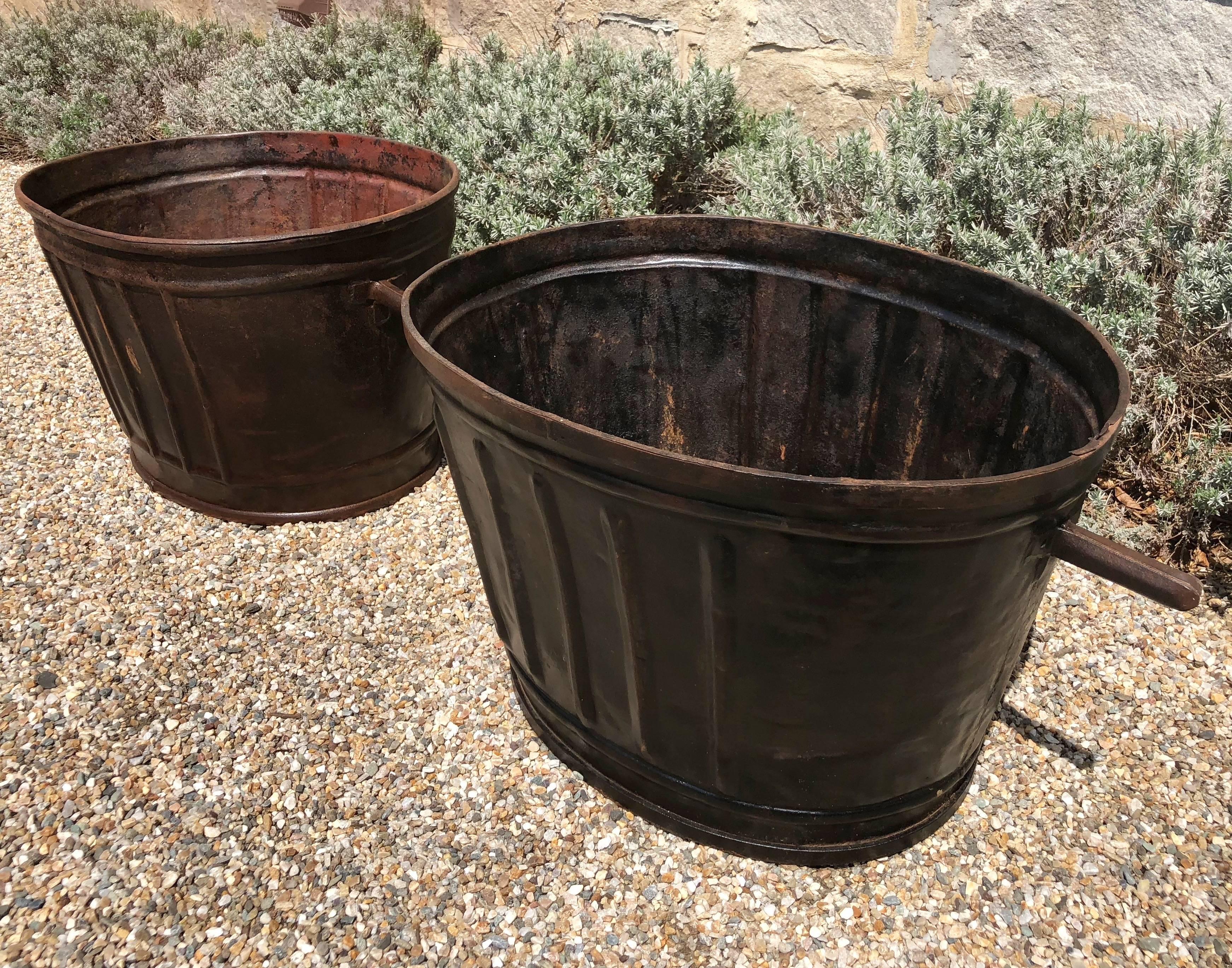This pair of steel wine-harvest buckets has been burnished to a stunning patina and would make wonderful planters or accessories in your wine cellar. From Burgundy, they both have a beautiful raised ribbed design on the exterior and are totally