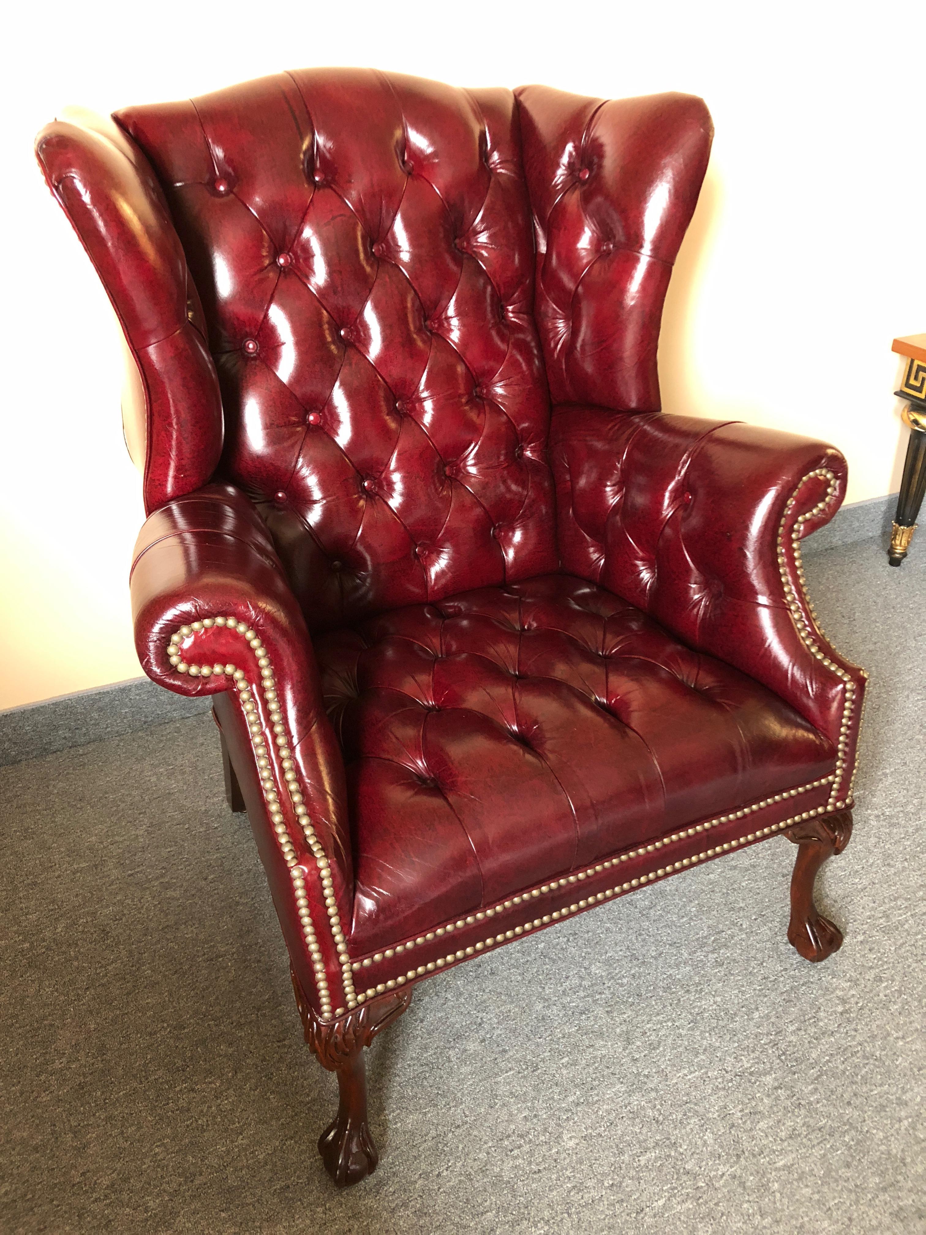 A rare find of two gorgeous tufted Chesterfield style wing chairs having rich burgundy leather upholstery and ball and claw mahogany feet, finished with handsome brass nailheads. Measures: Seat depth 19
Very comfortable.