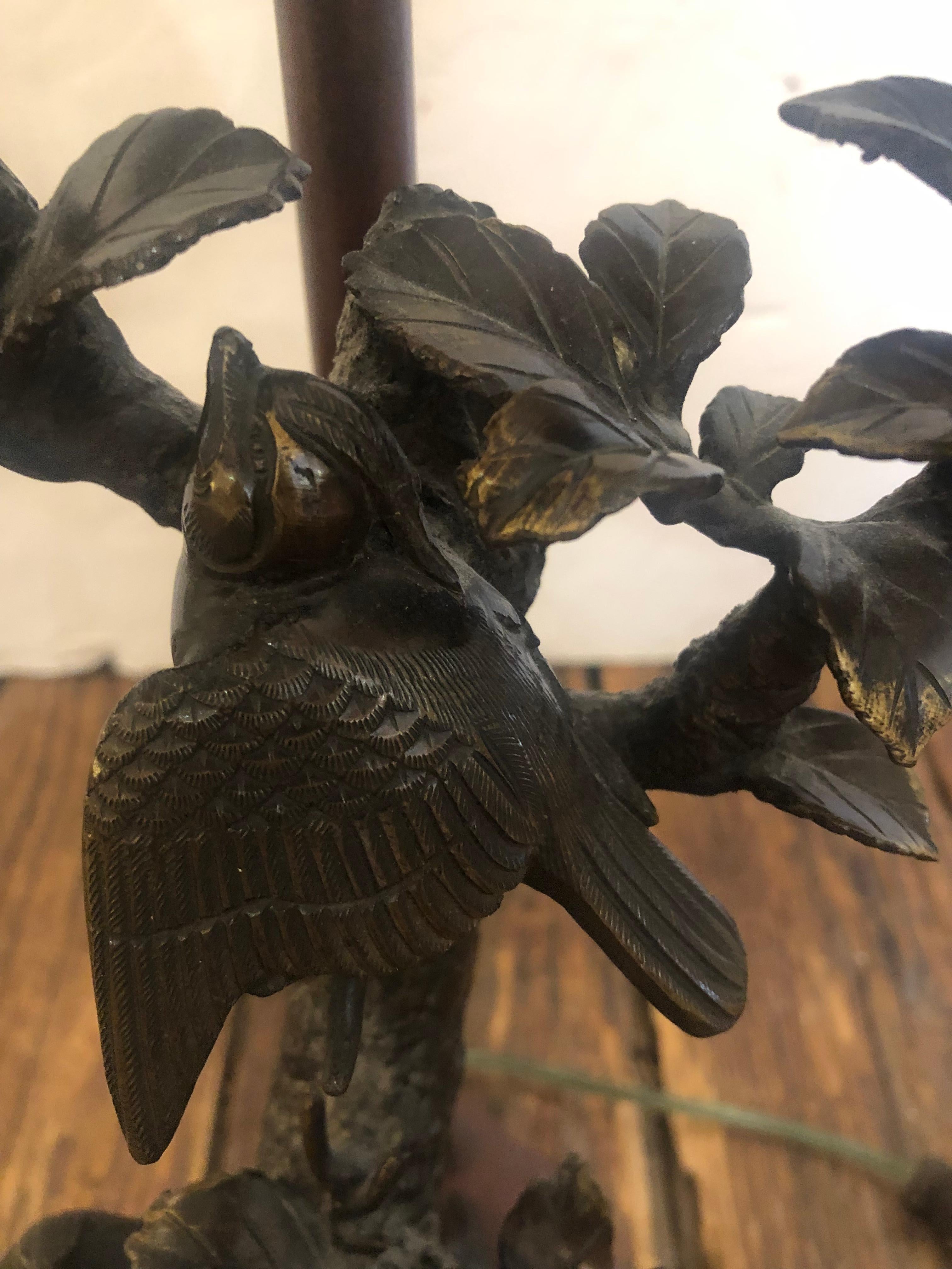 Pair of bronze faux bois lamps having intricate sculptural decoration with birds and leaves, marble bases, and dual arms with 2 bulbs. Wiring Good. Oval custom pleated shades.