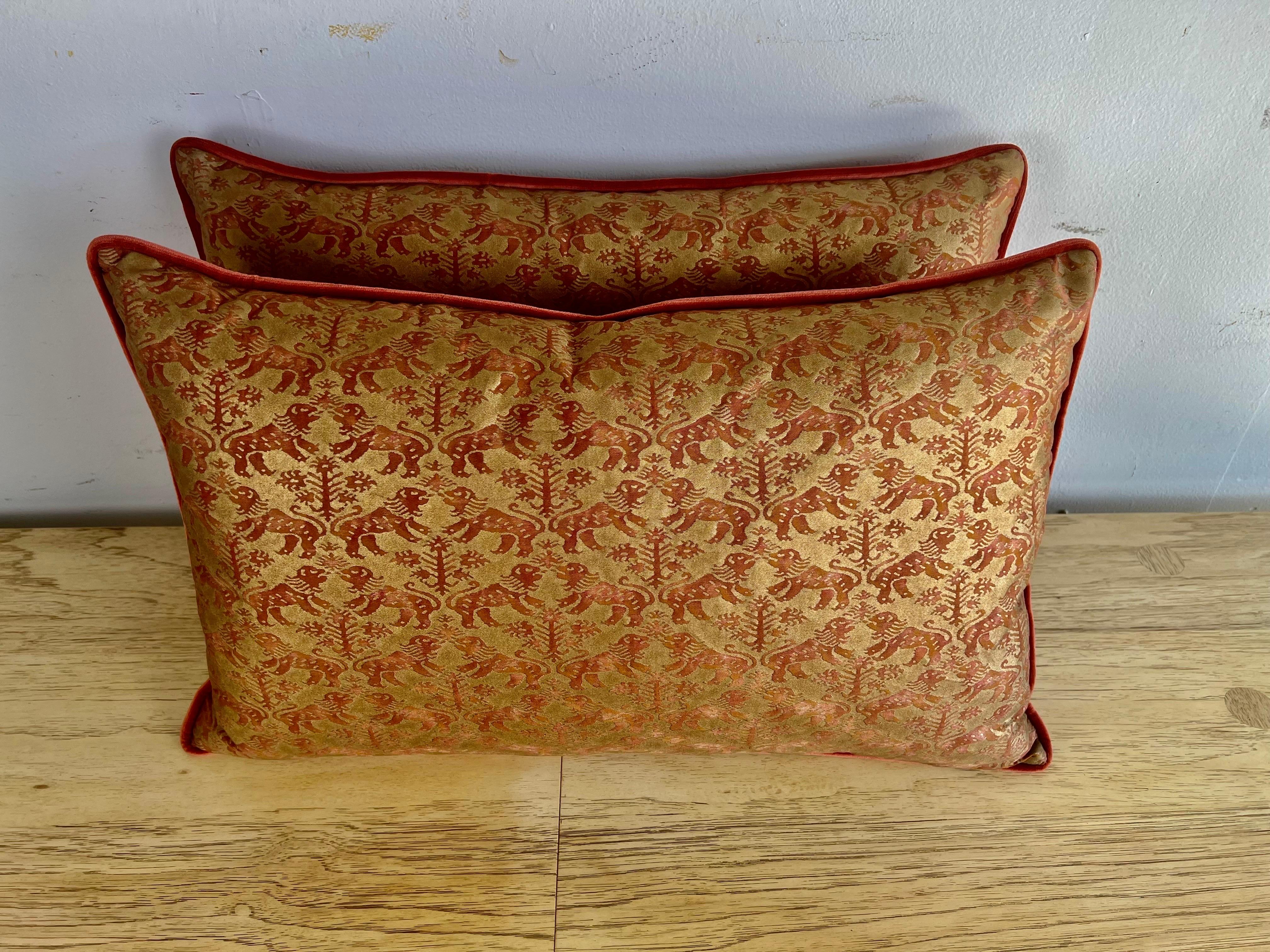 Pair of custom pillows made with vintage unused Fortuny stock in the Richeleau pattern in rust and metallic gold. Rust colored velvet backs with self cord detailing.  Down inserts, sewn closed.