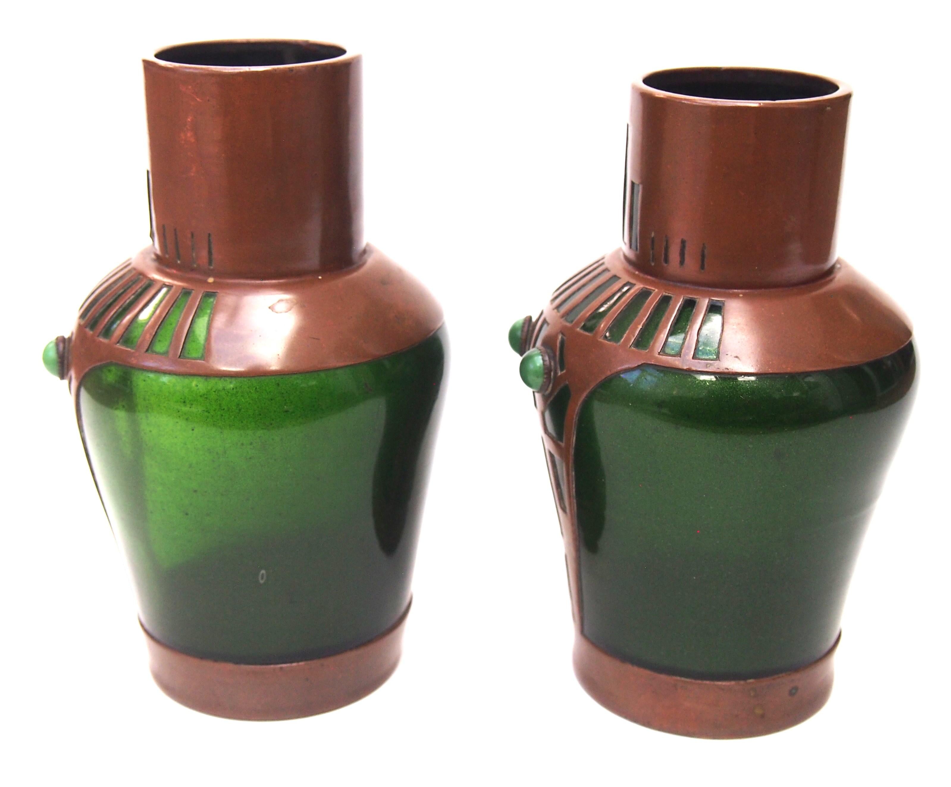 A stunning pair of copper clad Riedel green aventurine vases -with the cased copper pieced in a pattern to show a typical Vienna Secessionist design -Green aventurine is a glass colour that Riedel invented is dark green with a noticeable aventurine
