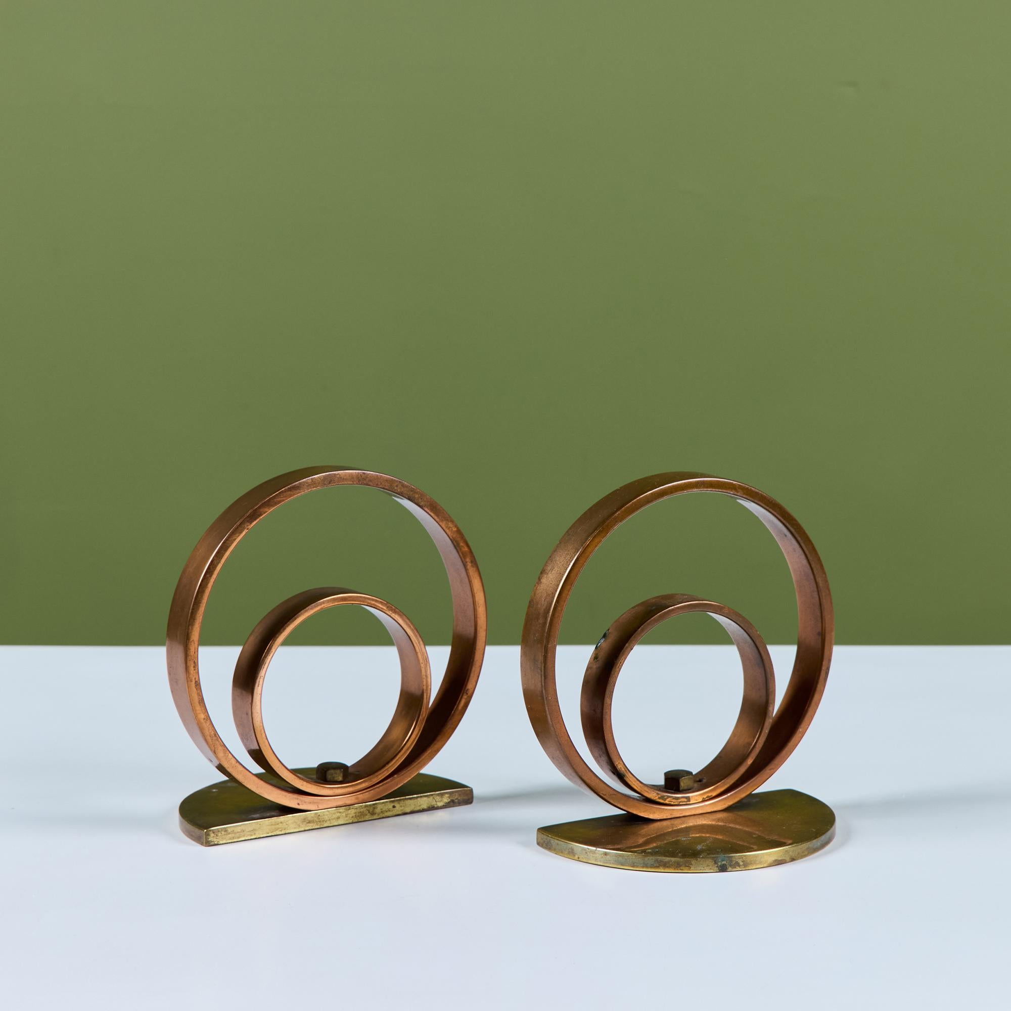 Coppia di fermalibri art déco in ottone e rame nello stile di Walter Von Nessen per Chase USA. La coppia di fermalibri presenta due cerchi, uno più grande e uno più piccolo, incastonati su una base semicircolare in ottone.

Dimensioni
Ogni